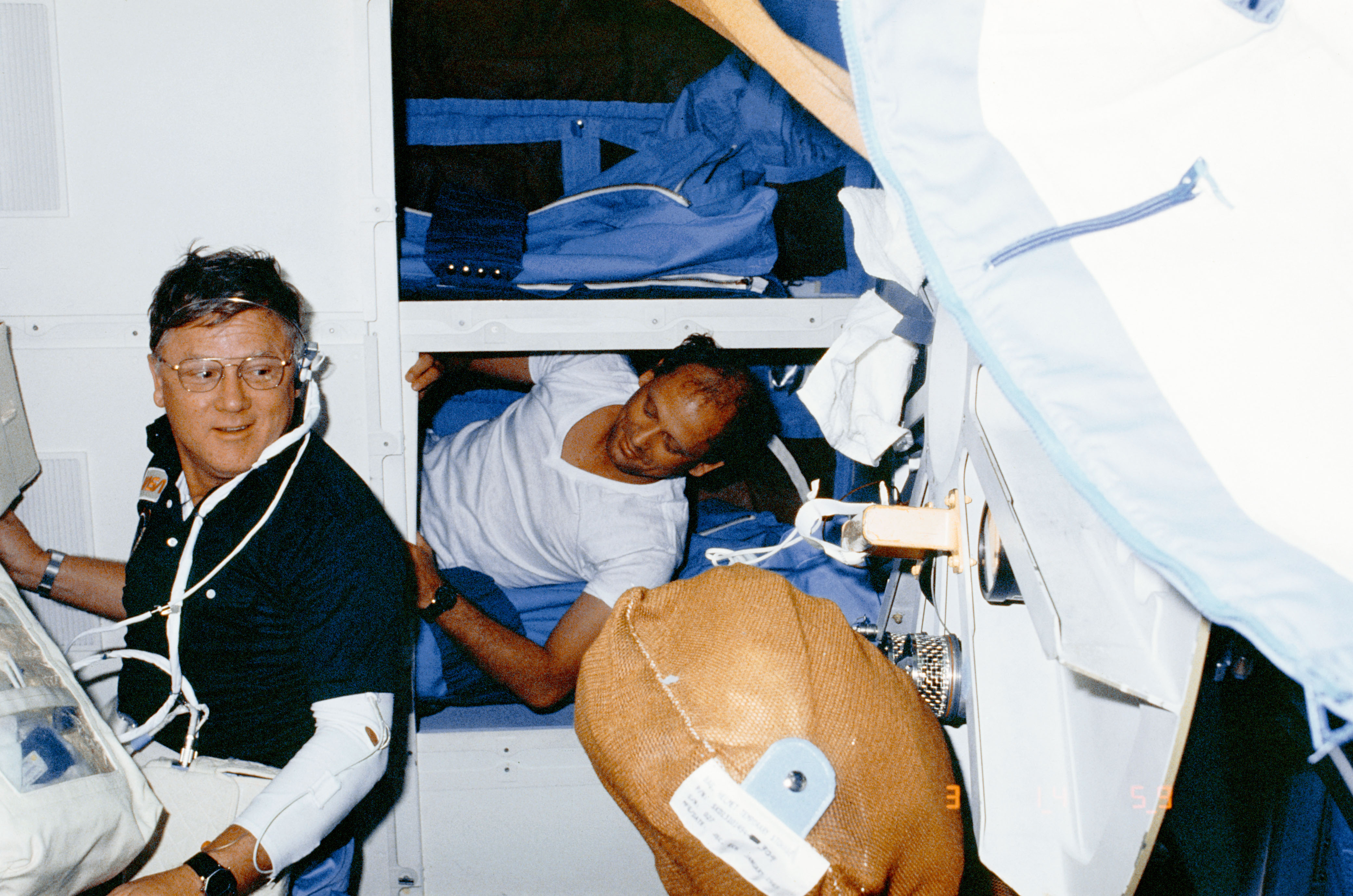 Astronaut Norman Thagard rests on middeck while other team is on duty