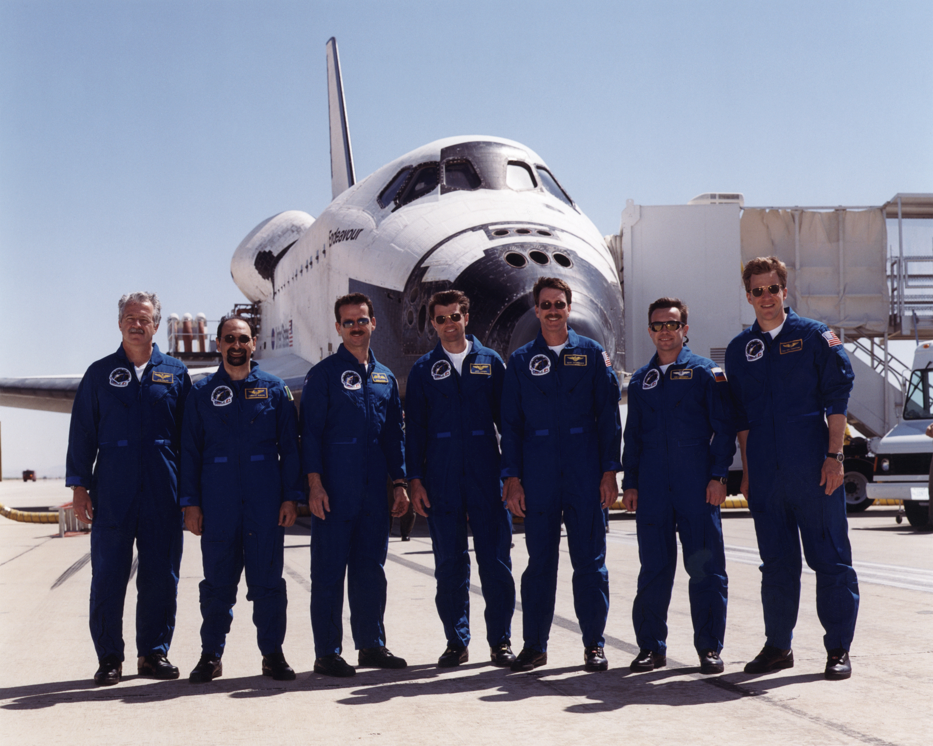 The crew of Space Shuttle mission STS-100 gathered in front of the shuttle Endeavour following landing at Edwards Air Force Base, California, 9:11 am, May 1, 2001
