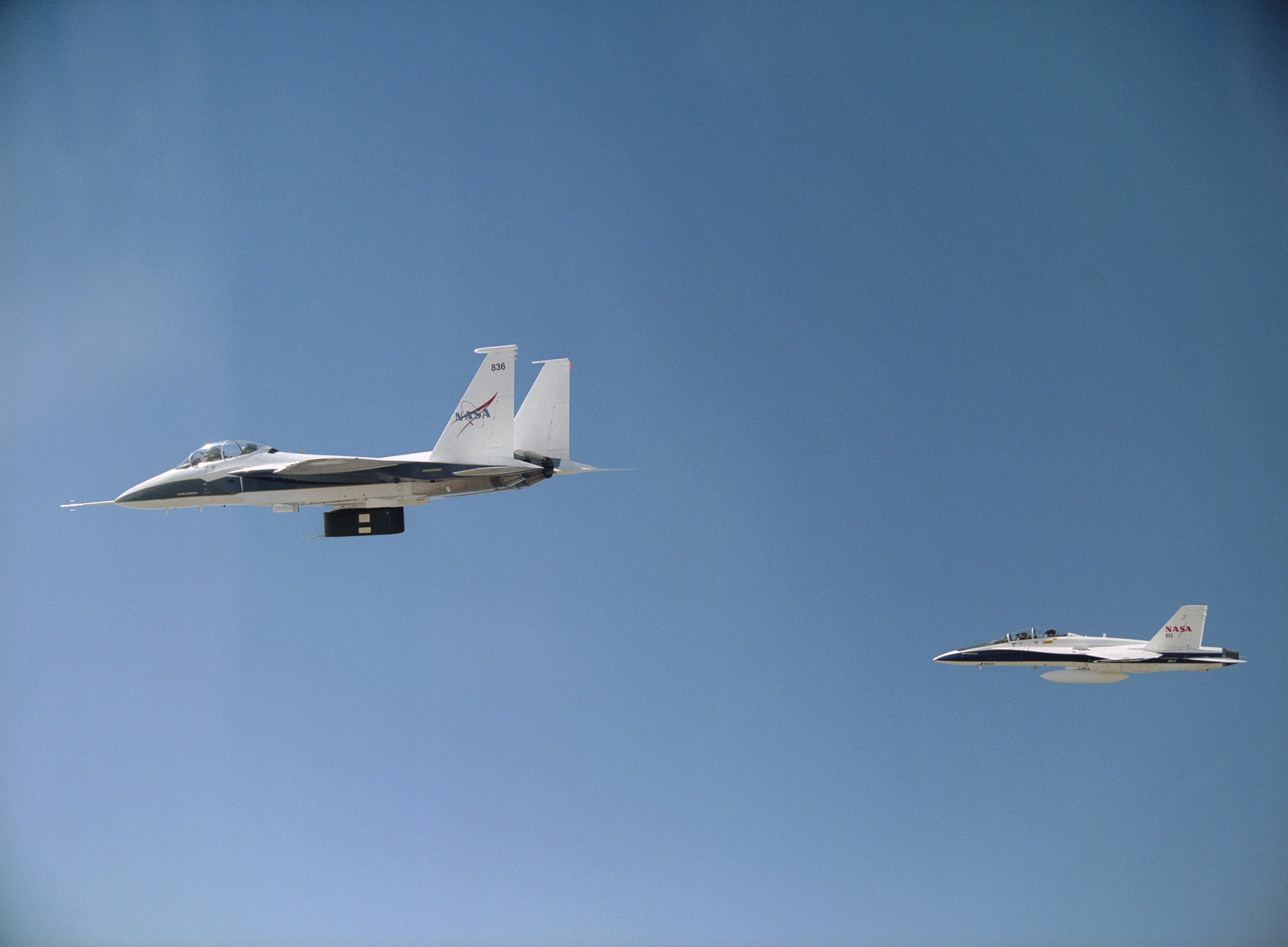 NASA's F-15B carrying thermal insulation foam on its flight test fixture is shadowed by a NASA F-18B chase aircraft during a LIFT experiment research flight.