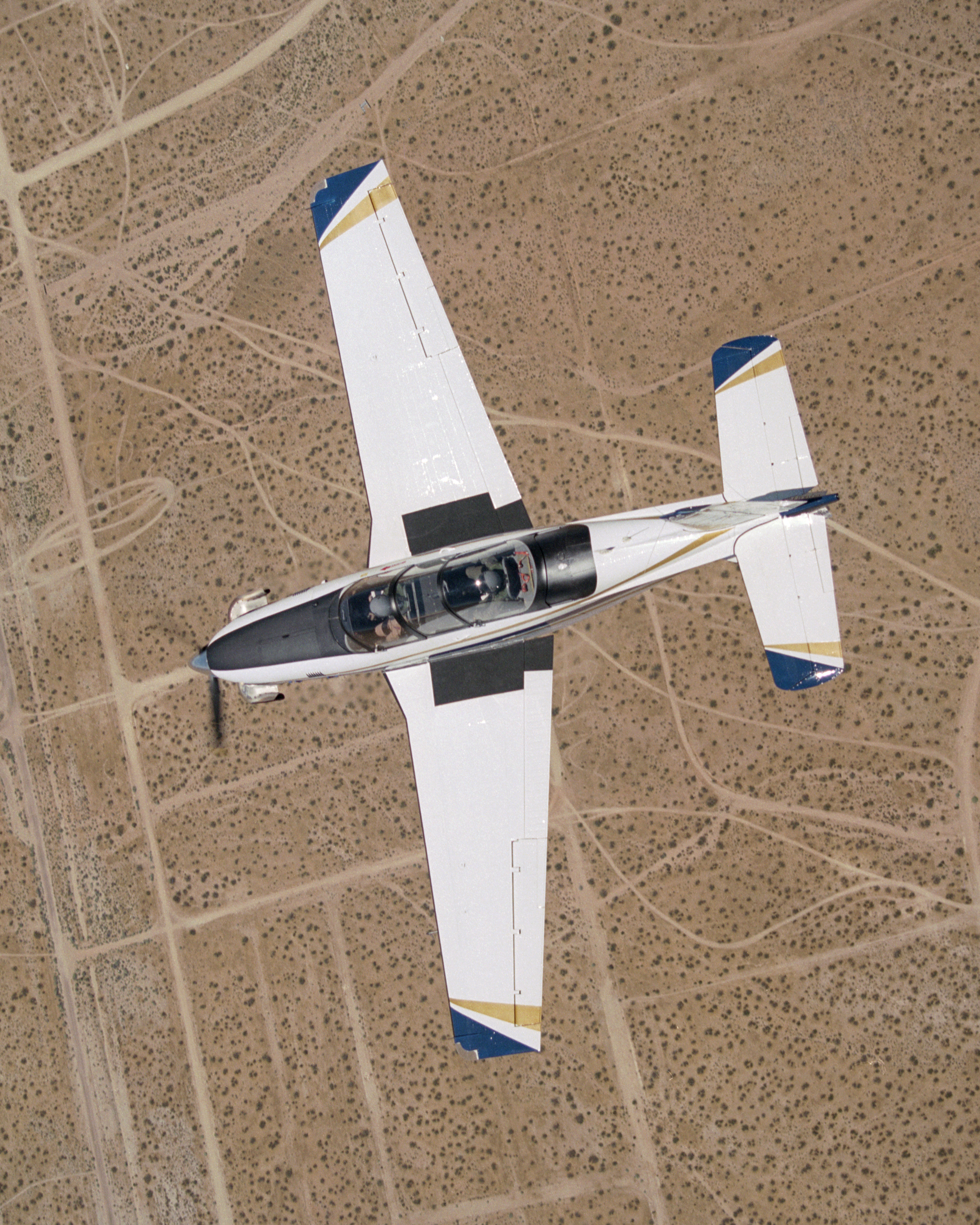 A Beech T-34C mission support aircraft flown by NASA Dryden Flight Research Center shows off its classic lines as it soars over the desert near Edwards AFB