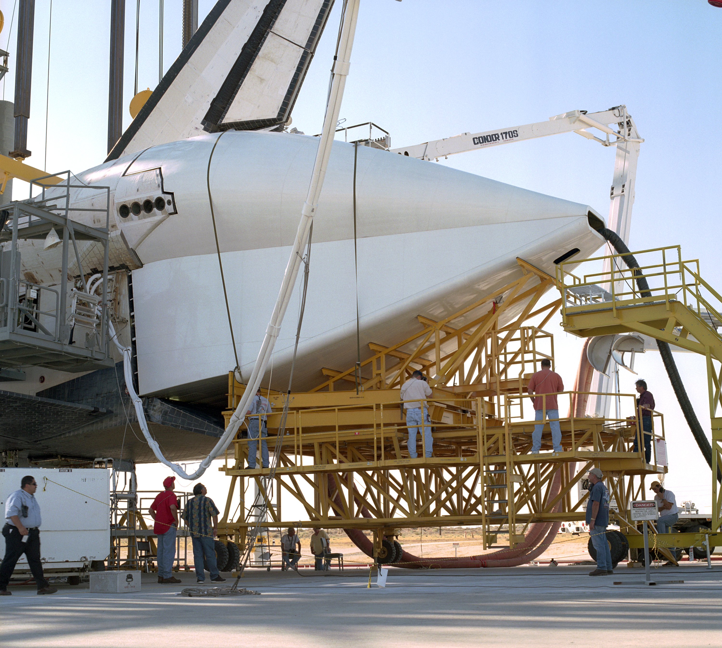 Technicians attach the tail cone to the Space Shuttle Discovery in preparation for its return to NASA's Kennedy Space Center in Florida