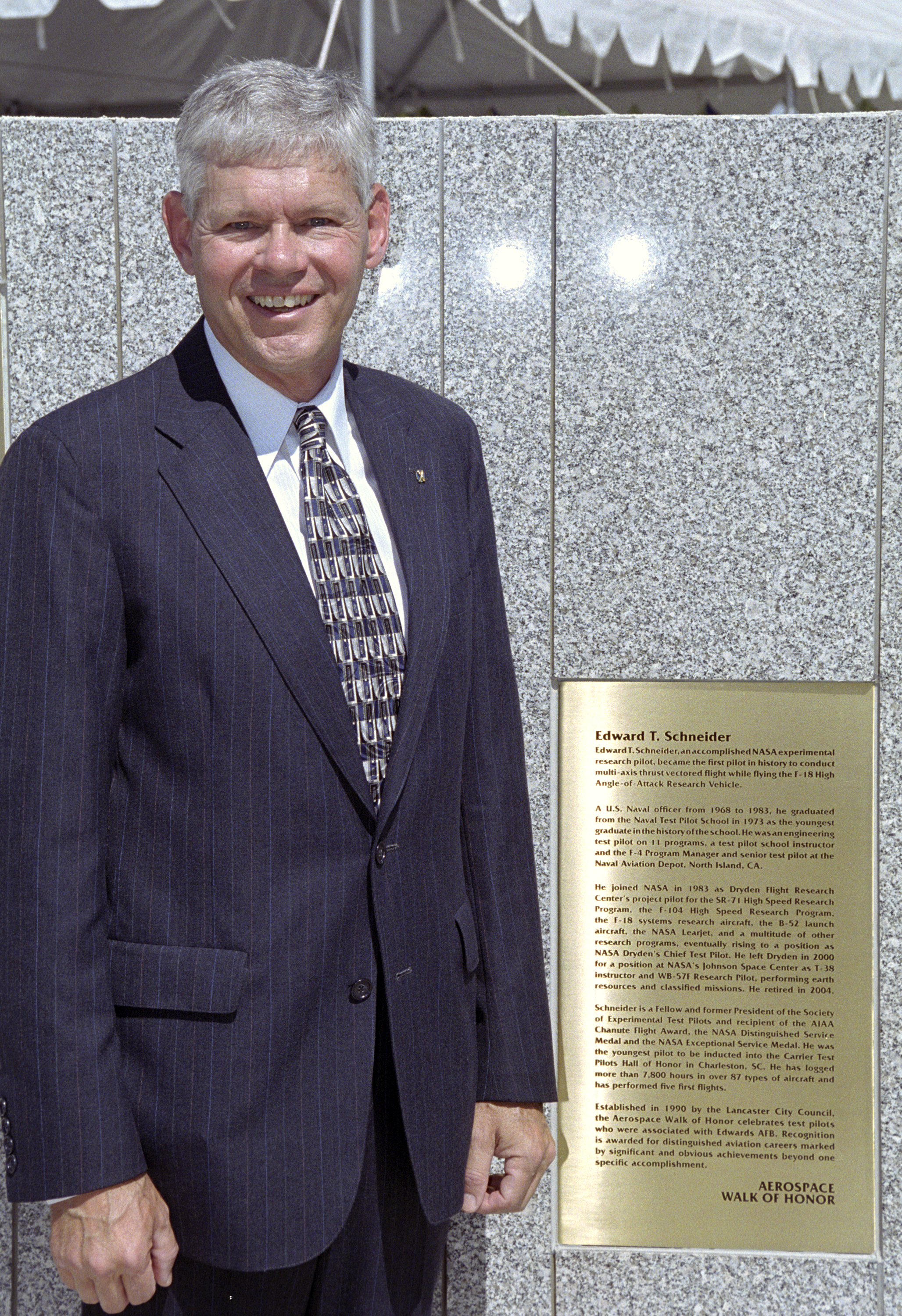 Former NASA research pilot Eddie Schneider with the brass plaque summarizing his career during the 2005 Aerospace Walk of Honor ceremonies in Lancaster, Calif.