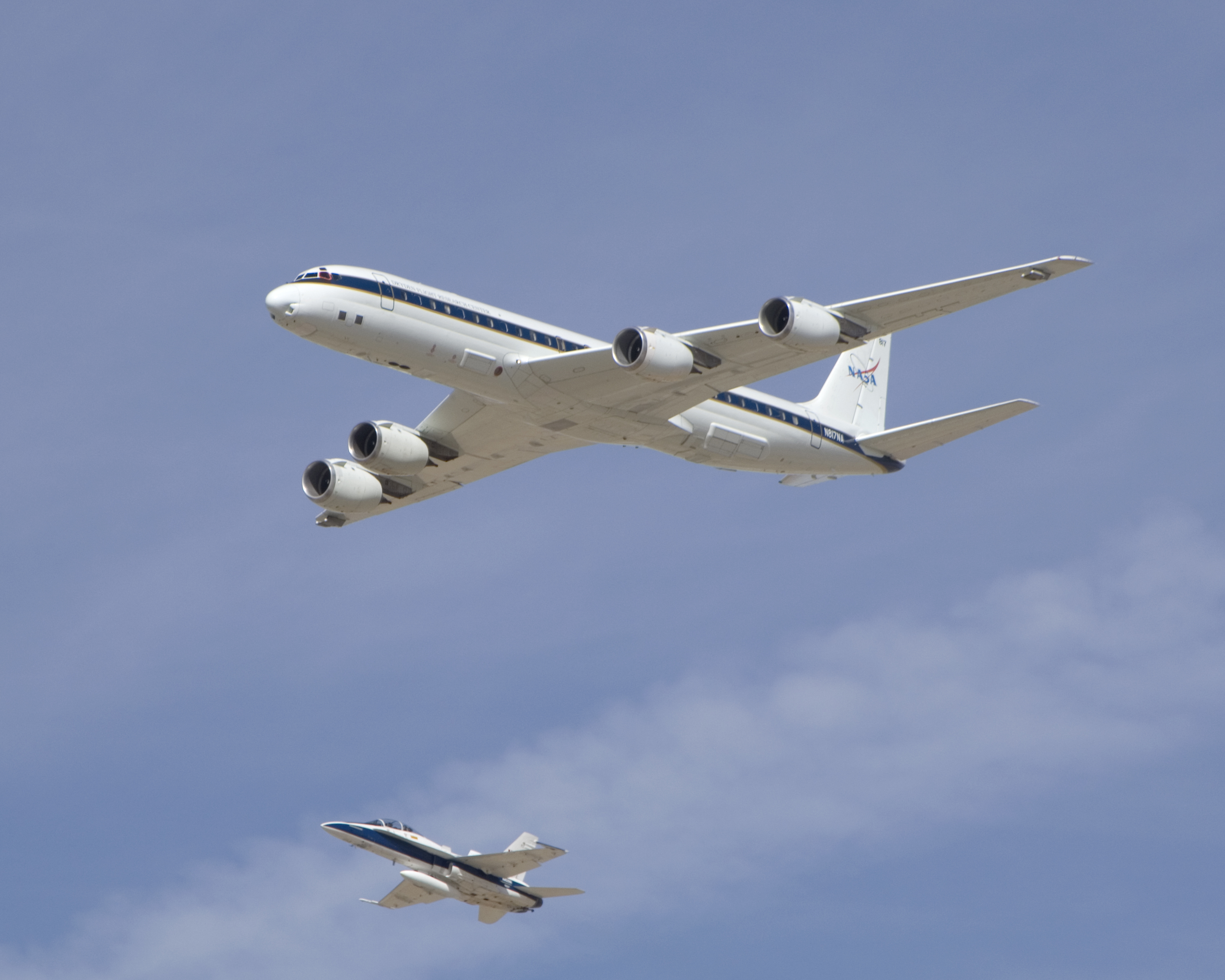 NASA's DC-8 airborne science laboratory is shadowed by a NASA F/A-18 chase plane during a flyover of the Dryden Aircraft Operations Facility in Palmdale, Calif.