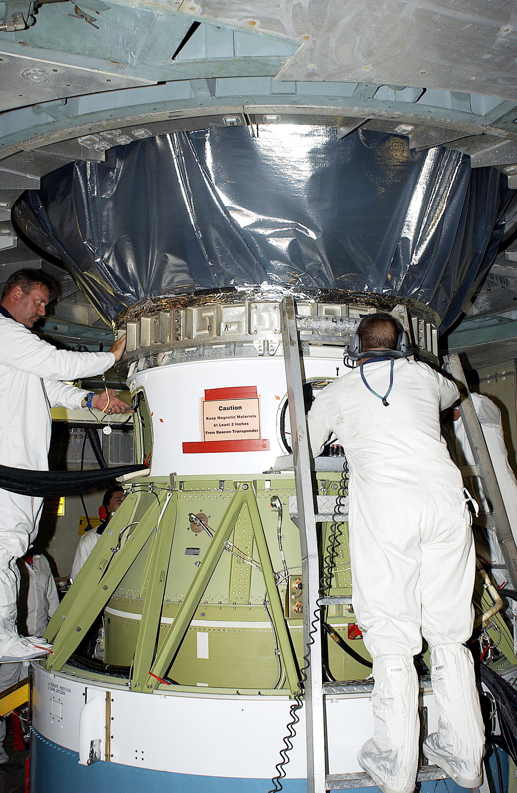 KENNEDY SPACE CENTER, FLA. - Workers on Launch Pad 17-B, Cape Canaveral Air Force Station, complete mating of the Mars Exploration Rover 1 (MER-B), above, to the Delta rocket below. The second of twin rovers being sent to Mars, it is equipped with a robotic arm, a drilling tool, three spectrometers, and four pairs of cameras that allow it to have a human-like, 3D view of the terrain. Each rover could travel as far as 100 meters in one day to act as Mars scientists' eyes and hands, exploring an environment where humans can't yet go. MER-B is scheduled to launch June 26 at one of two available times, 12:27:31 a.m. EDT or 1:08:45 a.m. EDT.