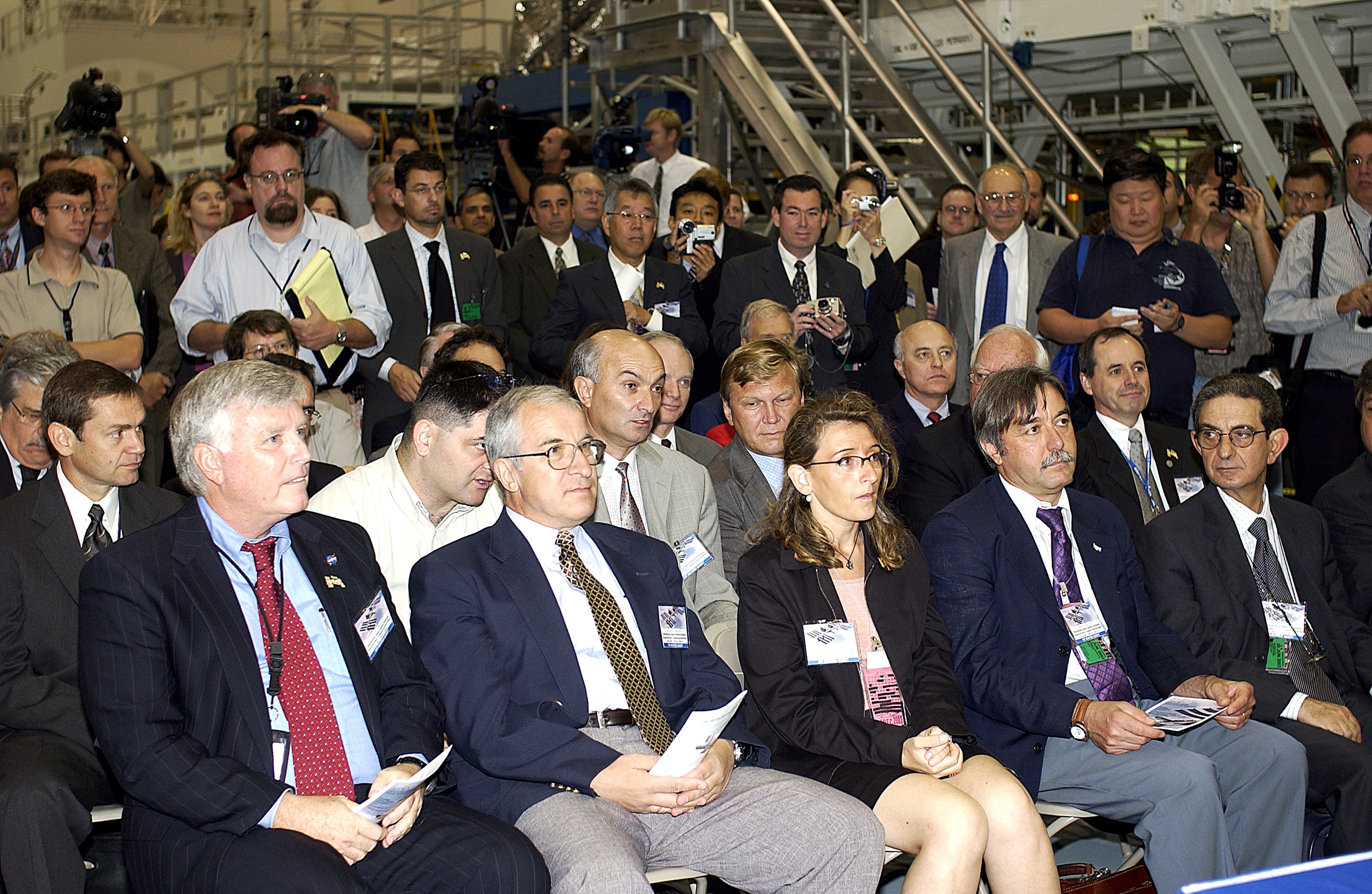 KENNEDY SPACE CENTER, FLA. - In the Space Station Processing Facility, media and guests listen intently to remarks during a ceremony to highlight the arrival of two major components of the International Space Station. NASA's Node 2, built by the European Space Agency (ESA) in Italy arrived at KSC on June 1. It will be the next pressurized module installed on the Station. The pressurized module of the Japanese Experiment Module (JEM), named "Kibo" (Hope) arrived at KSC on June 4. It is Japan's primary contribution to the Station. The ceremony held today included the official transfer of ownership signing of Node 2 between the ESA and NASA.. Emceed by Lisa Malone, deputy director of External Relations and Business Development at KSC, the ceremony included these speakers: KSC Director Roy Bridges Jr.; NASA's Michael C. Kostelnik, deputy associate administrator for International Space Station and Shuttle Programs, and William Gerstenmaier, International Space Station Program manager; Alan Thirkettle, International Space Station Program manager for Node 2, ESA; Andrea Lorenzoni, International Space Station Program manager for Node 2, Italian Space Agency; Kuniaki Shiraki, JEM Project manager, National Aerospace and Development Agency of Japan.