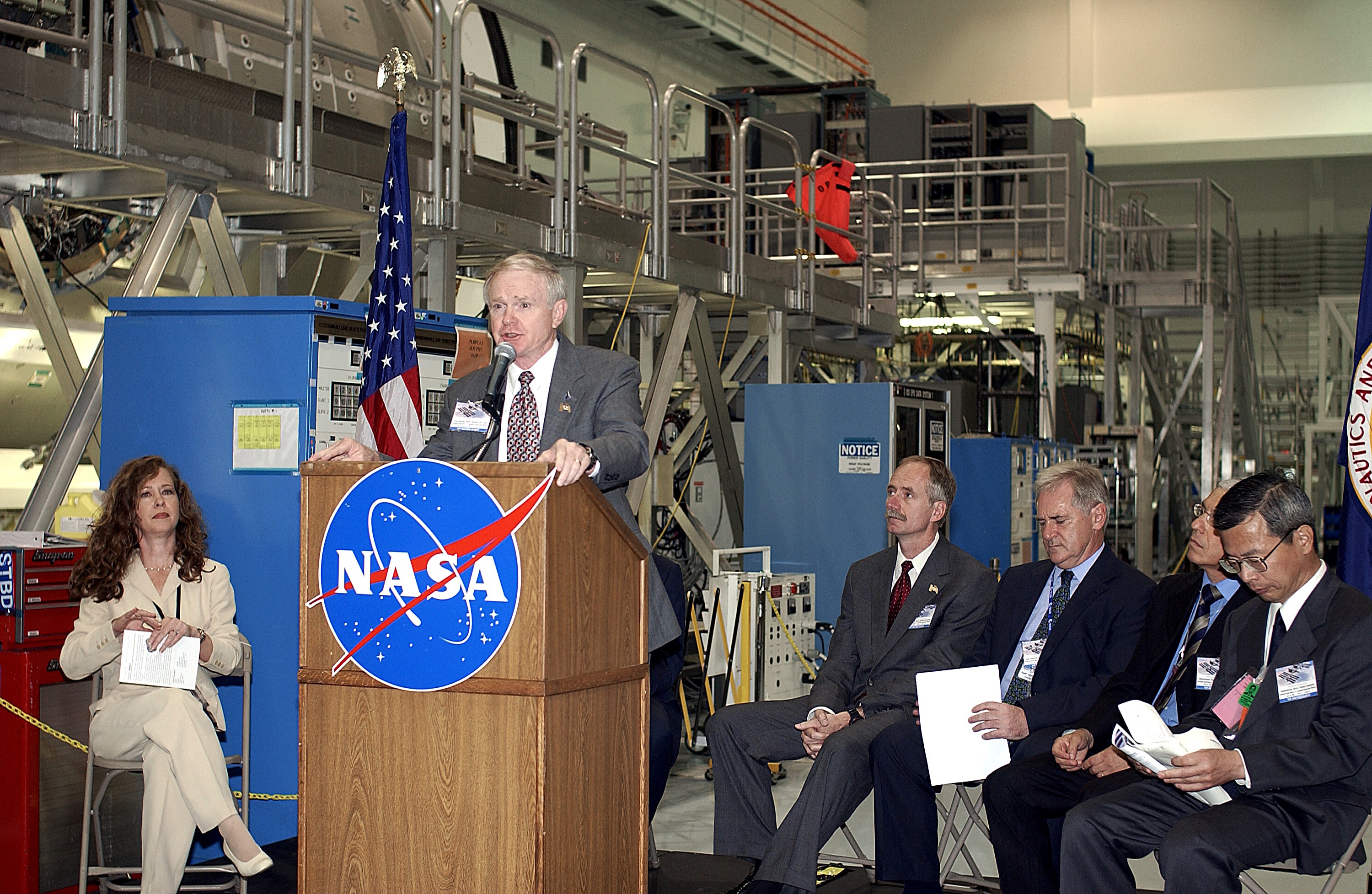 KENNEDY SPACE CENTER, FLA. - Center Director Roy Bridges Jr. speaks to the media and guests gathered in the Space Station Processing Facility for a ceremony to highlight the arrival of two major components of the International Space Station. NASA's Node 2, built by the European Space Agency (ESA) in Italy arrived at KSC on June 1. It will be the next pressurized module installed on the Station. The pressurized module of the Japanese Experiment Module (JEM), named "Kibo" (Hope) arrived at KSC on June 4. It is Japan's primary contribution to the Station. The ceremony held today included the official transfer of ownership signing of Node 2 between the ESA and NASA.. Emceed by Lisa Malone (left) , deputy director of External Relations and Business Development at KSC, the ceremony also included these speakers: NASA's Michael C. Kostelnik, deputy associate administrator for International Space Station and Shuttle Programs, and William Gerstenmaier, International Space Station Program manager; Alan Thirkettle, International Space Station Program manager for Node 2, ESA; Andrea Lorenzoni, International Space Station Program manager for Node 2, Italian Space Agency; Kuniaki Shiraki, JEM Project manager, National Aerospace and Development Agency of Japan.