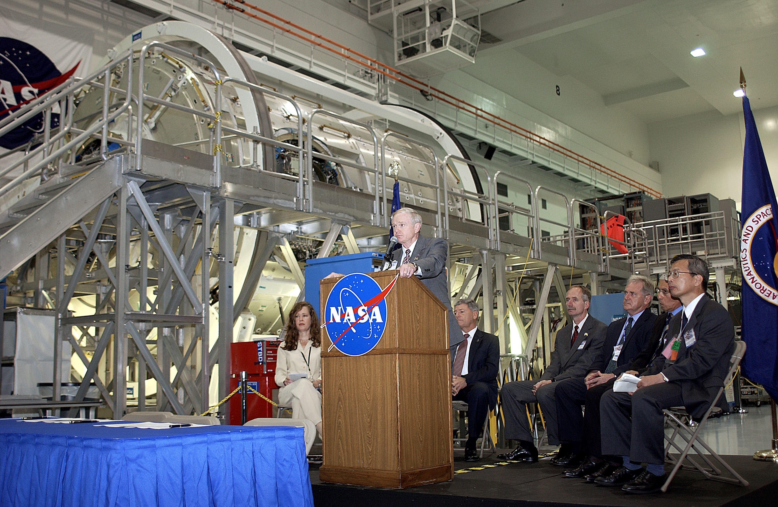 KENNEDY SPACE CENTER, FLA. - Center Director Roy Bridges Jr. speaks to the media and guests gathered in the Space Station Processing Facility for a ceremony to highlight the arrival of two major components of the International Space Station. NASA's Node 2, built by the European Space Agency (ESA) in Italy arrived at KSC on June 1. It will be the next pressurized module installed on the Station. The pressurized module of the Japanese Experiment Module (JEM), named "Kibo" (Hope) arrived at KSC on June 4. It is Japan's primary contribution to the Station. The ceremony held today included the official transfer of ownership signing of Node 2 between the ESA and NASA.. Emceed by Lisa Malone (left), deputy director of External Relations and Business Development at KSC, the ceremony also included these speakers: NASA's Michael C. Kostelnik, deputy associate administrator for International Space Station and Shuttle Programs, and William Gerstenmaier, International Space Station Program manager; Alan Thirkettle, International Space Station Program manager for Node 2, ESA; Andrea Lorenzoni, International Space Station Program manager for Node 2, Italian Space Agency; Kuniaki Shiraki, JEM Project manager, National Aerospace and Development Agency of Japan.