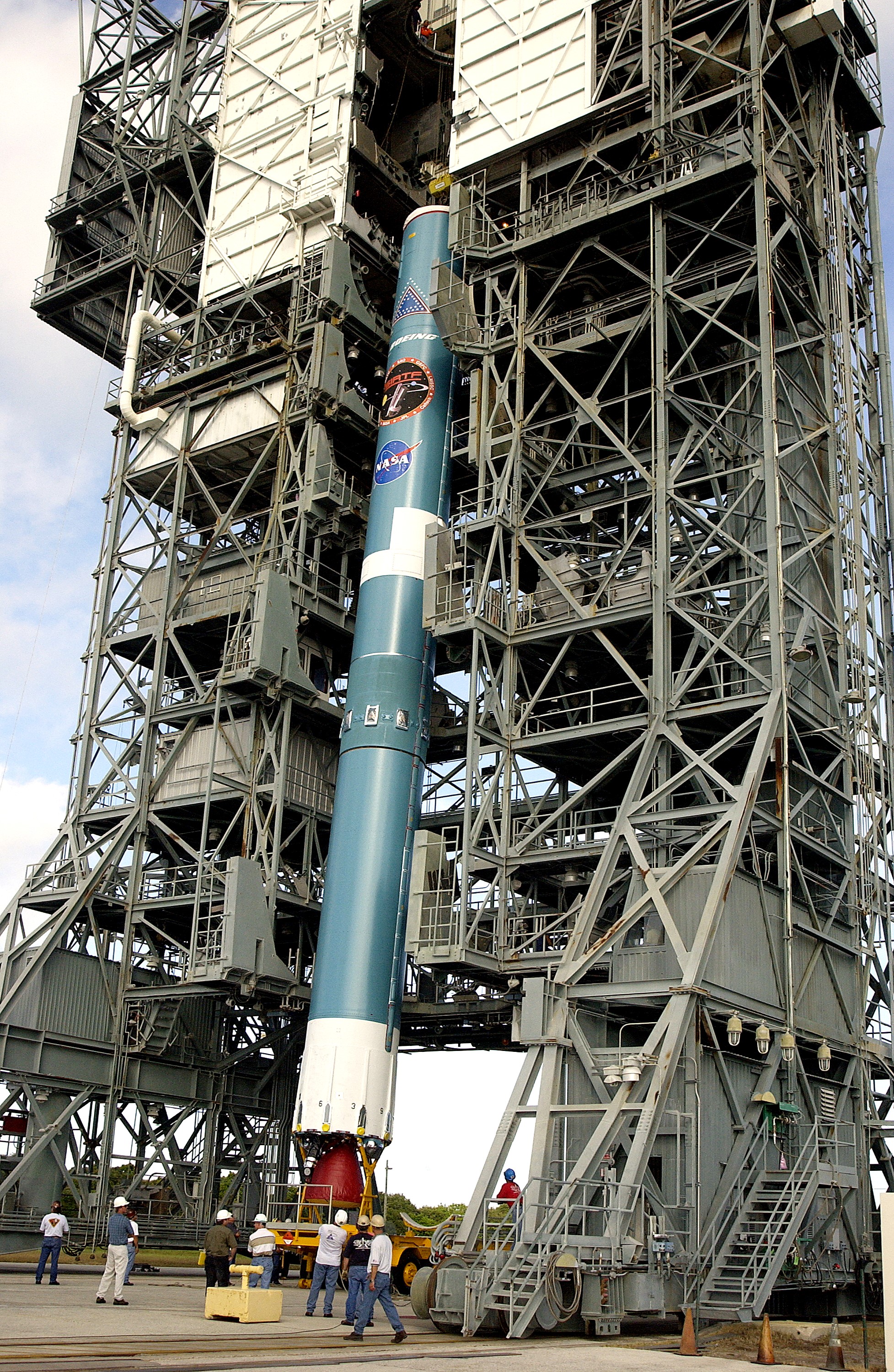 KENNEDY SPACE CENTER, FLA. - On Launch Complex 17-B, Cape Canaveral Air Force Station, the first stage of a Delta II rocket is moved into the mobile service tower. The rocket is being erected to launch the Space InfraRed Telescope Facility (SIRTF). Consisting of an 0.85-meter telescope and three cryogenically cooled science instruments, SIRTF is one of NASA's largest infrared telescopes to be launched. SIRTF will obtain images and spectra by detecting the infrared energy, or heat, radiated by objects in space. Most of this infrared radiation is blocked by the Earth's atmosphere and cannot be observed from the ground.