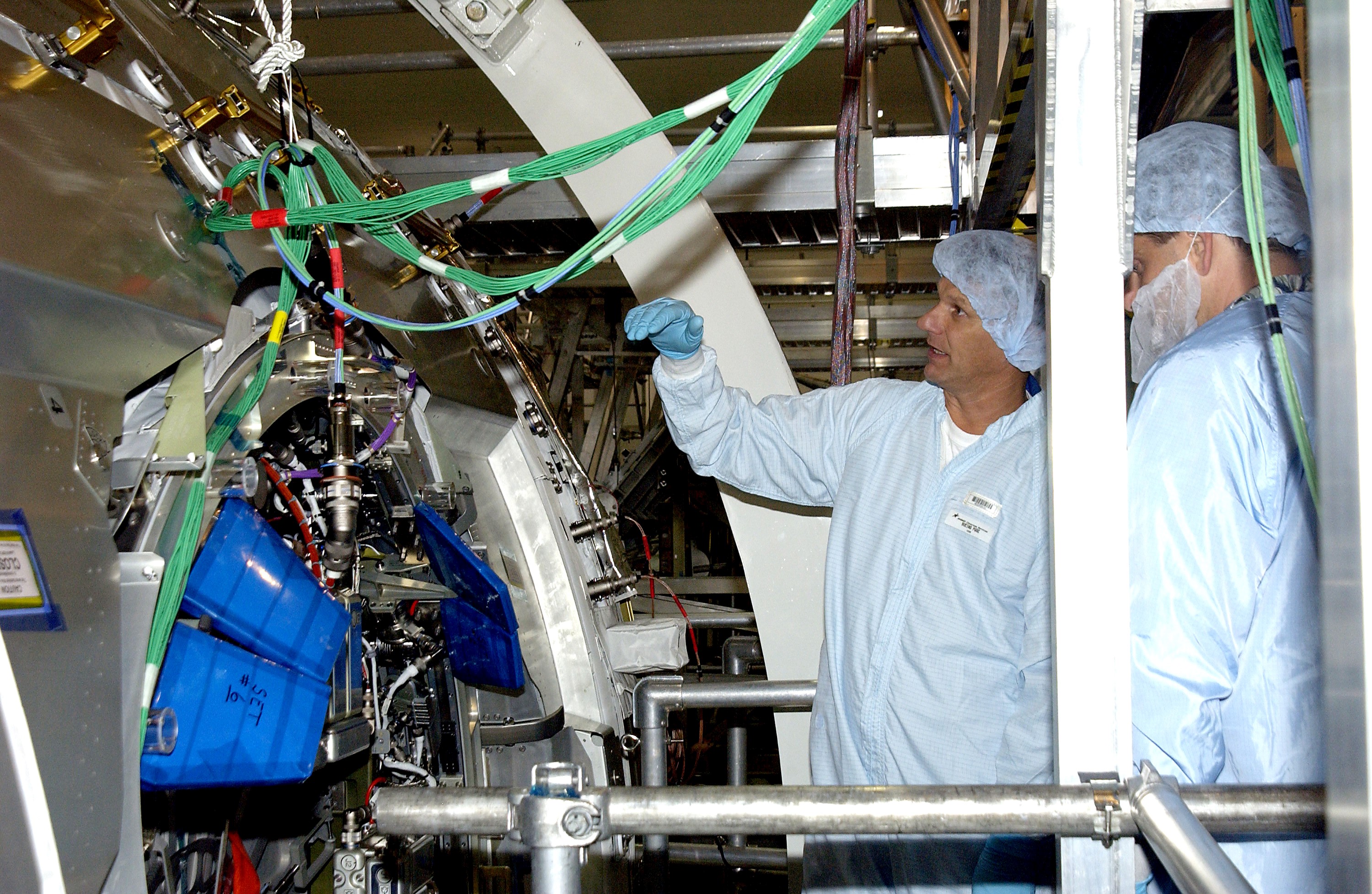 KENNEDY SPACE CENTER, FLA. - STS-120 Mission Specialists Piers Sellers and Michael Foreman look at the Japanese Experiment Module (JEM) Pressurized Module located in the Space Station Processing Facility. Known as Kibo, the JEM consists of six components: two research facilities -- the Pressurized Module and Exposed Facility; a Logistics Module attached to each of them; a Remote Manipulator System; and an Inter-Orbit Communication System unit. Kibo also has a scientific airlock through which experiments are transferred and exposed to the external environment of space. The various components of JEM will be assembled in space over the course of three Space Shuttle missions. The STS-120 mission will deliver the second of three Station connecting modules, Node 2, which attaches to the end of U.S. Lab. It will provide attach locations for the JEM, European laboratory, the Centrifuge Accommodation Module and later Multi-Purpose Logistics Modules. The addition of Node 2 will complete the U.S. core of the International Space Station.