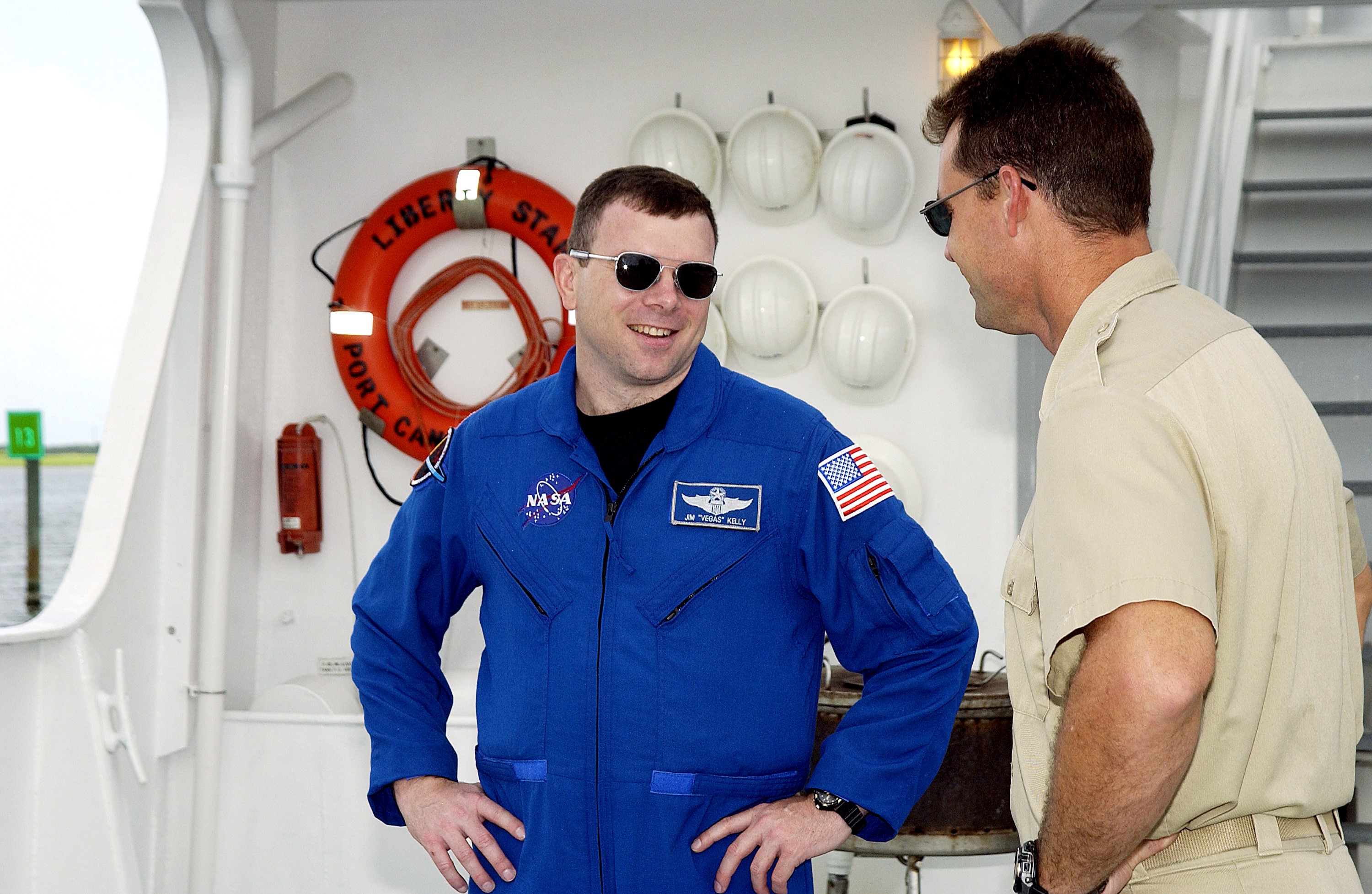 KENNEDY SPACE CENTER, FLA. - STS-114 Pilot James Kelly talks with Bren Wade, captain of the Liberty Star, one of the SRB Retrieval Ships docked at Hangar AF on the Banana River. Kelly and other crew members Commander Eileen Collins and Mission Specialists Soichi Noguchi and Stephen Robinson toured the ships. Noguchi is with the Japanese space agency NASDA. Mission STS-114 will carry the MultiPurpose Logistics Module (MPLM) Raffaello and External Stowage Platform 2 to the International Space Station. The MPLM will contain supplies and equipment. Another goal of the mission is to remove and replace a Control Moment Gyro. Launch date for mission STS-114 is under review.