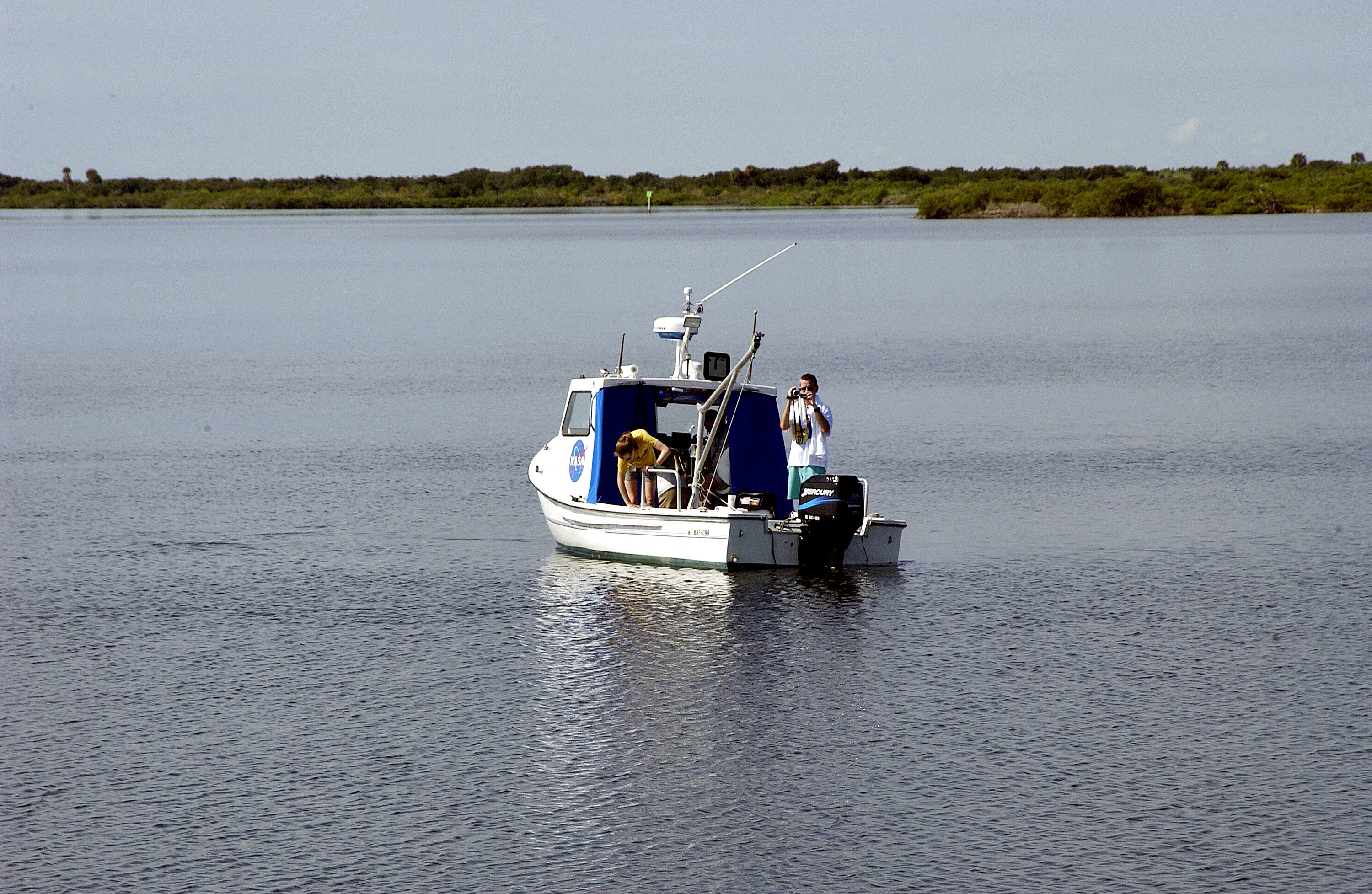 KENNEDY SPACE CENTER, FLA. - Researchers are positioned on one of the watercraft being utilized to conduct underwater acoustic research in the Launch Complex 39 turn basin. Several government agencies, including NASA, NOAA, the Navy, the Coast Guard, and the Florida Fish and Wildlife Commission are involved in the testing. The research involves demonstrations of passive and active sensor technologies, with applications in fields ranging from marine biological research to homeland security. The work is also serving as a pilot project to assess the cooperation between the agencies involved. Equipment under development includes a passive acoustic monitor developed by NASA’s Jet Propulsion Laboratory, and mobile robotic sensors from the Navy’s Mobile Diving and Salvage Unit.