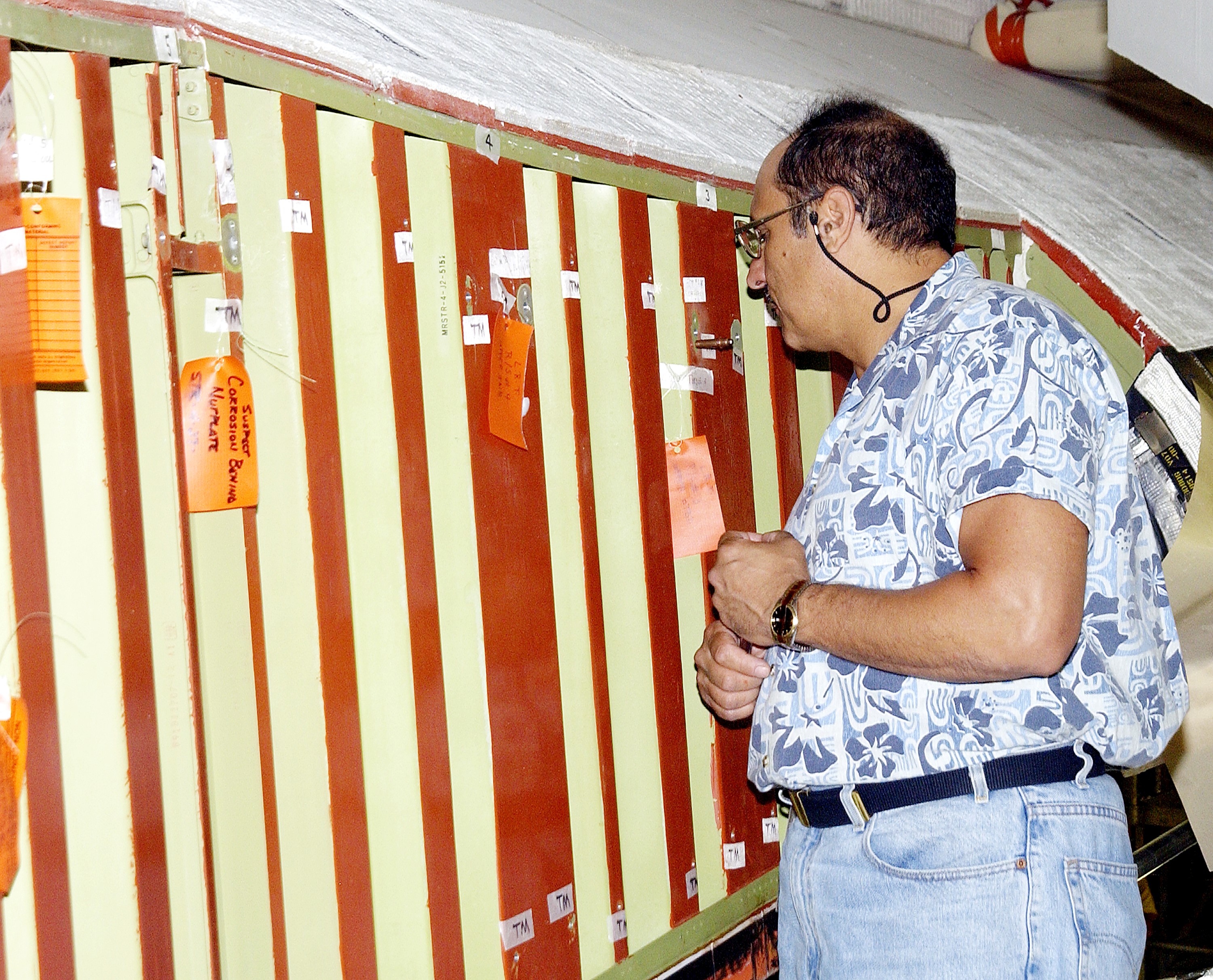KENNEDY SPACE CENTER, FLA. - In the Orbiter Processing Facility (OPF), a United Space Alliance technician examines the attachment points for the spars on the exterior of a wing of Space Shuttle Atlantis. Reinforced Carbon Carbon (RCC) panels are mechanically attached to the wing with a series of floating joints - spars - to reduce loading on the panels caused by wing deflections. The aluminum and the metallic attachments are protected from exceeding temperature limits by internal insulation. The next launch of Atlantis will be on mission STS-114, a utilization and logistics flight to the International Space Station.