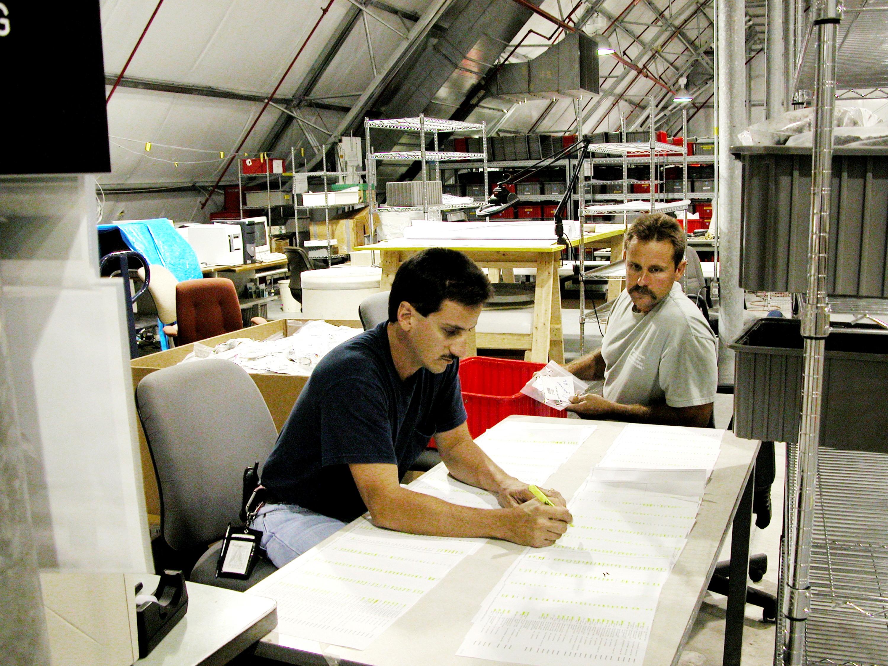 KENNEDY SPACE CENTER, FLA. - Workers in the Columbia Debris Hangar record the first items of the STS-107 debris to be transferred to storage in the Vehicle Assembly Building. About 83,000 pieces were shipped to KSC during search and recovery efforts in East Texas.