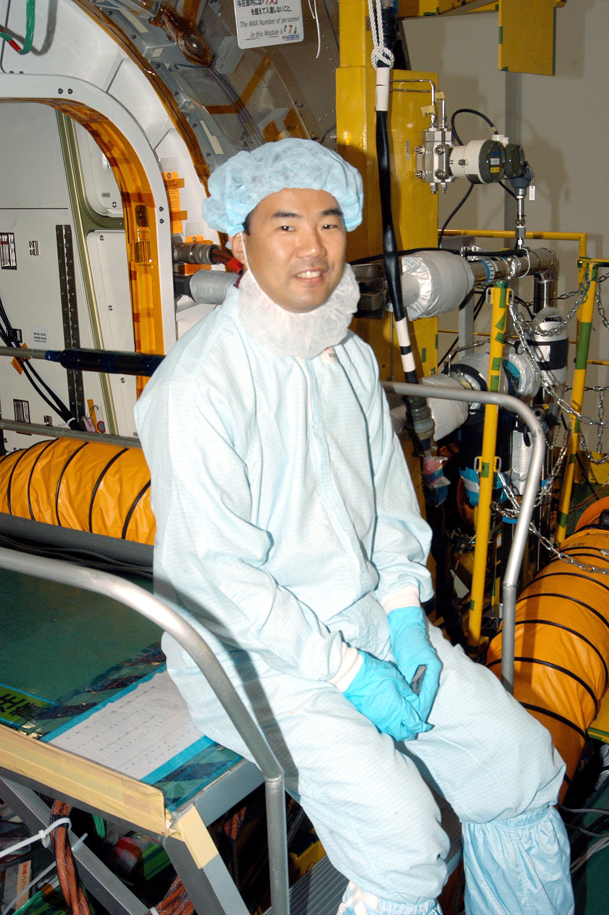 KENNEDY SPACE CENTER, FLA. - Astronaut Soichi Noguchi, with the National Space Development Agency of Japan (NASDA), rests inside the Japanese Experiment Module (JEM), undergoing a Multi-Element Integrated Test (MEIT) in the Space Station Processing Facility. Noguchi is assigned to mission STS-114 as a mission specialist. Node 2 attaches to the end of the U.S. Lab on the ISS and provides attach locations for the Japanese laboratory, European laboratory, the Centrifuge Accommodation Module and, eventually, Multipurpose Logistics Modules. It will provide the primary docking location for the Shuttle when a pressurized mating adapter is attached to Node 2. Installation of the module will complete the U.S. Core of the ISS. The JEM, developed by NASDA, is Japan's primary contribution to the Station. It will enhance the unique research capabilities of the orbiting complex by providing an additional environment for astronauts to conduct science experiments.
