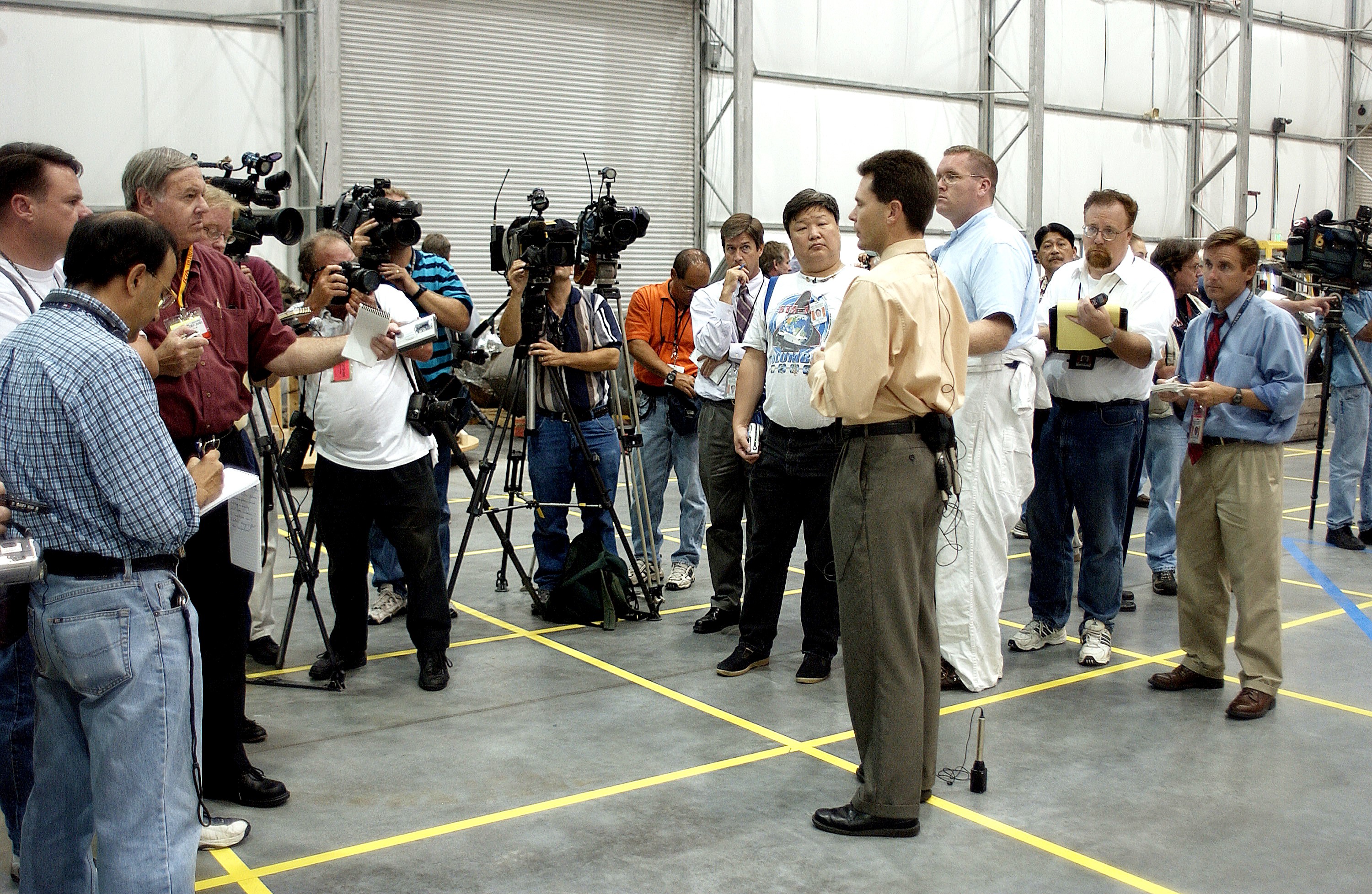 KENNEDY SPACE CENTER, FLA. - In the Columbia Debris Hangar, Scott Thurston, NASA vehicle flow manager, addresses the media about efforts to pack the debris stored in the Columbia Debris Hangar. More than 83,000 pieces of debris were shipped to KSC during search and recovery efforts in East Texas. That represents about 38 percent of the dry weight of Columbia, equaling almost 85,000 pounds. An area of the Vehicle Assembly Building is being prepared to store the debris permanently.