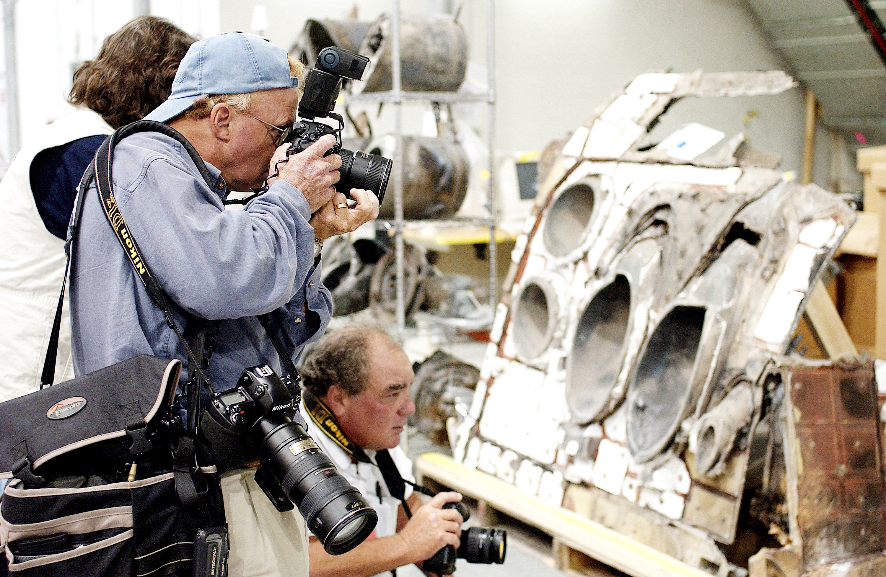 KENNEDY SPACE CENTER, FLA. - During a media tour of the Columbia Debris Hangar, photographers focus on a piece of the debris collected from search and recovery efforts in East Texas. About 83,000 pieces of debris from Columbia were shipped to KSC, which represents about 38 percent of the dry weight of Columbia, equaling almost 85,000 pounds. The debris is being packaged for storage in an area of the Vehicle Assembly Building.