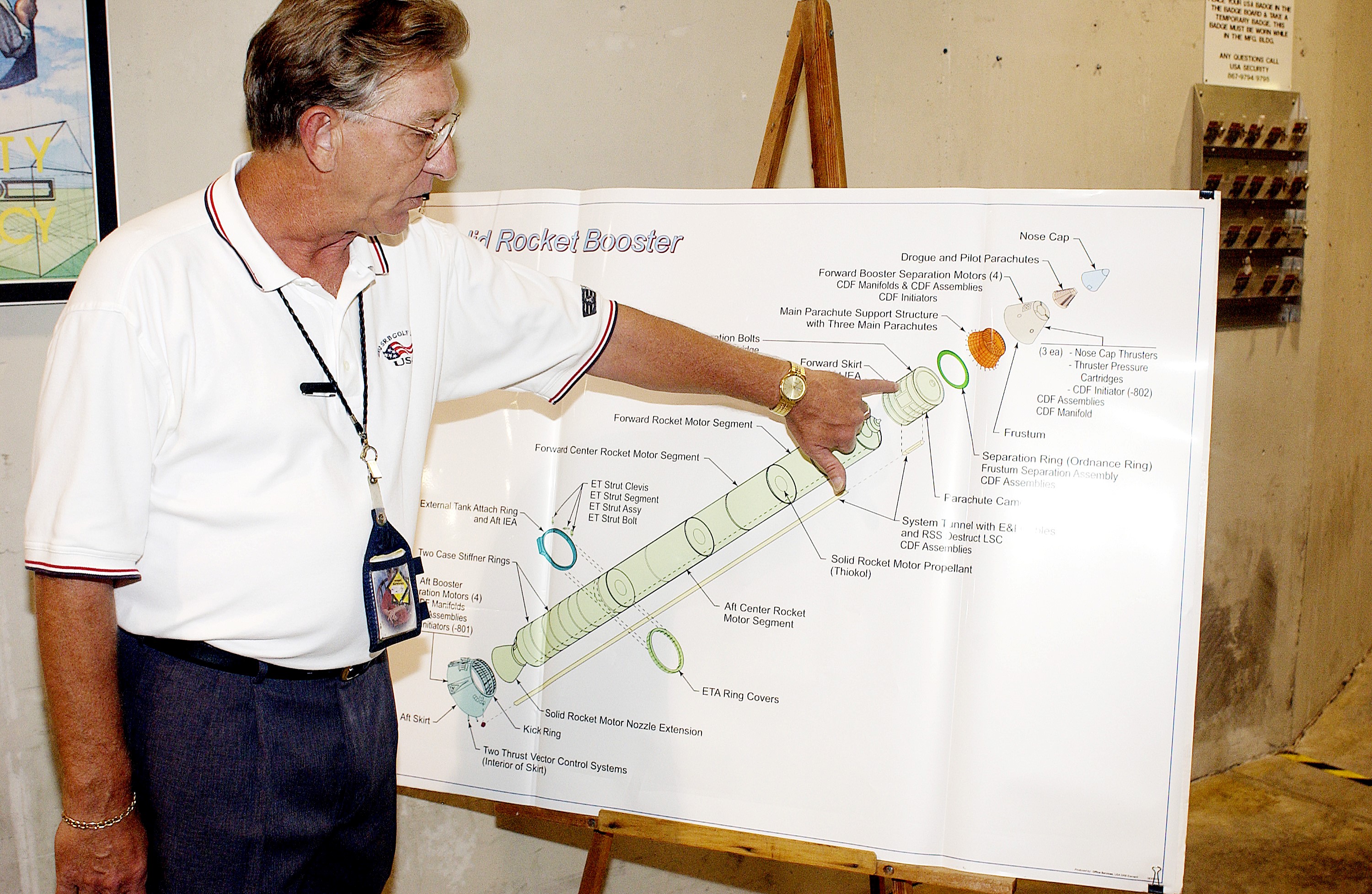 KENNEDY SPACE CENTER, FLA. - On a drawing of a solid rocket booster (SRB), Mark Northcraft, with United Space Alliance, points to the spot where a parachute camera will be installed, on the forward skirt of the SRB. The work is being done in the Solid Rocket Booster Assembly and Refurbishment Facility, which routinely carries out refurbishment and subassembly of Shuttle SRB hardware.