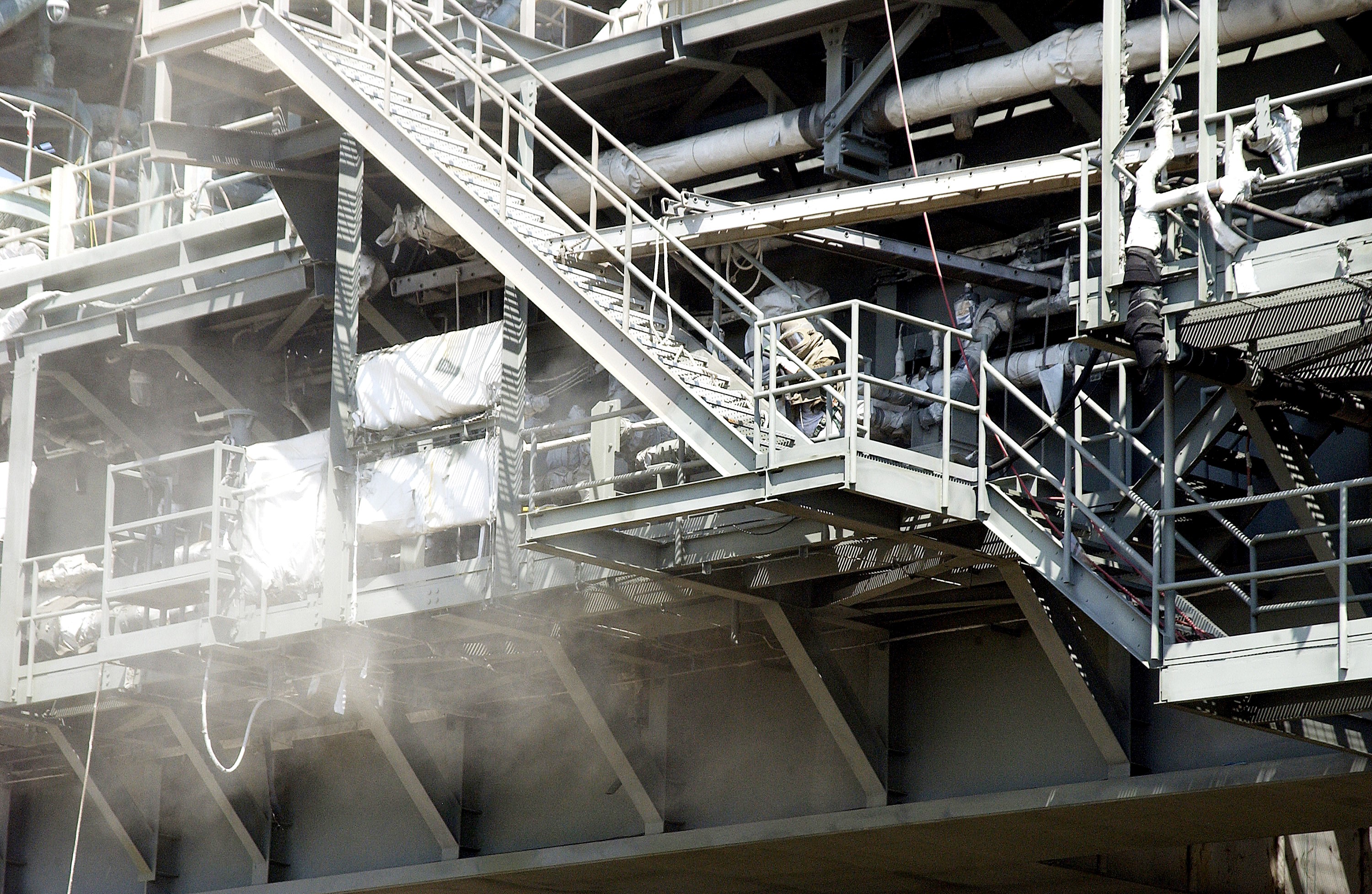 KENNEDY SPACE CENTER, FLA. - Workers, covered in protective clothing and breathing apparatus, continue sandblasting on the Mobile Launcher Platform on Launch Pad 39A to remove corrosion before repainting. Routine maintenance includes sandblasting and repainting as preventive means to minimize corrosion.