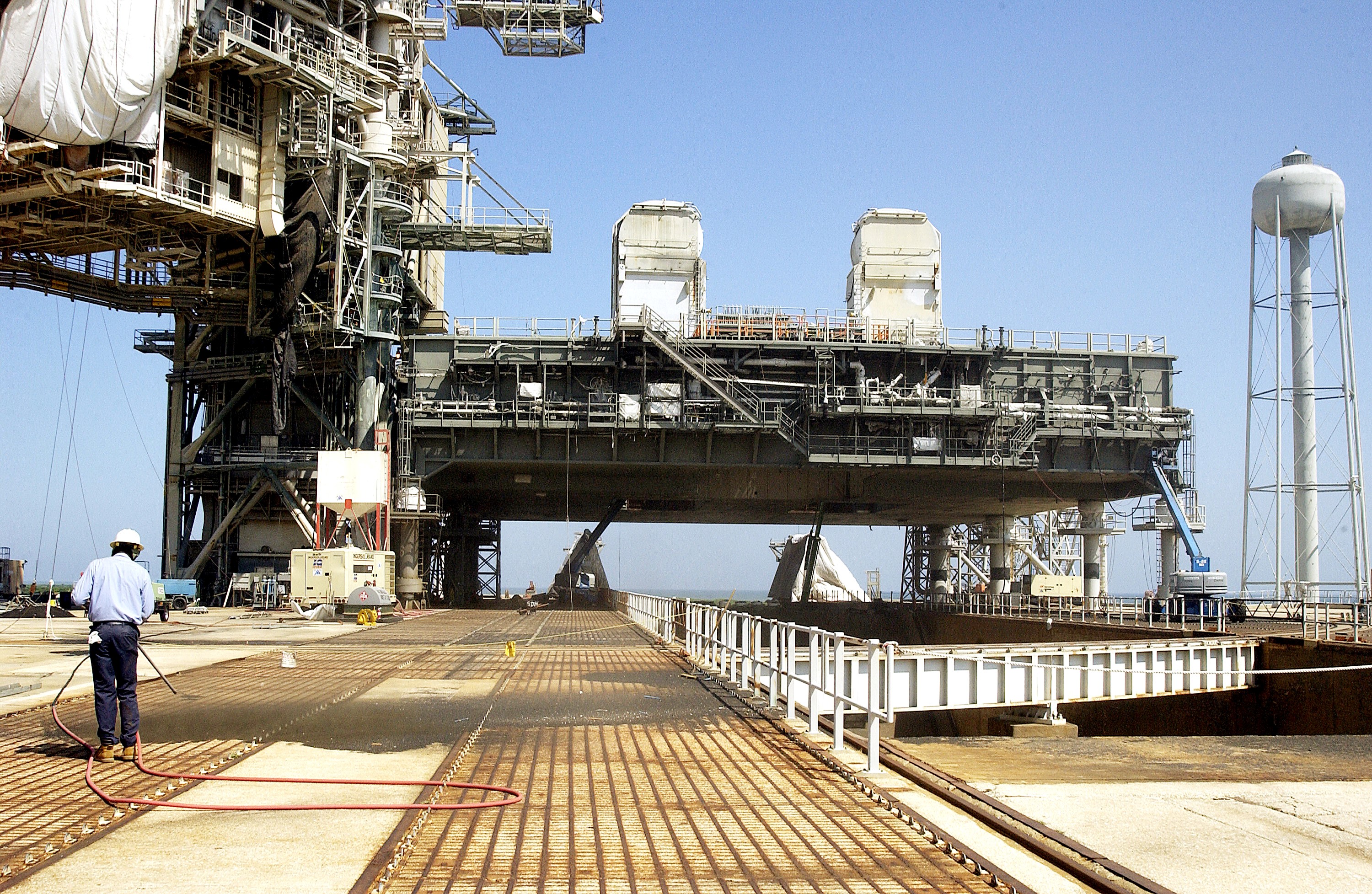 KENNEDY SPACE CENTER, FLA. - A worker sandblasts the surface behind the Mobile Launcher Platform on Launch Pad 39A . Routine maintenance includes sandblasting and repainting as preventive means to minimize corrosion.