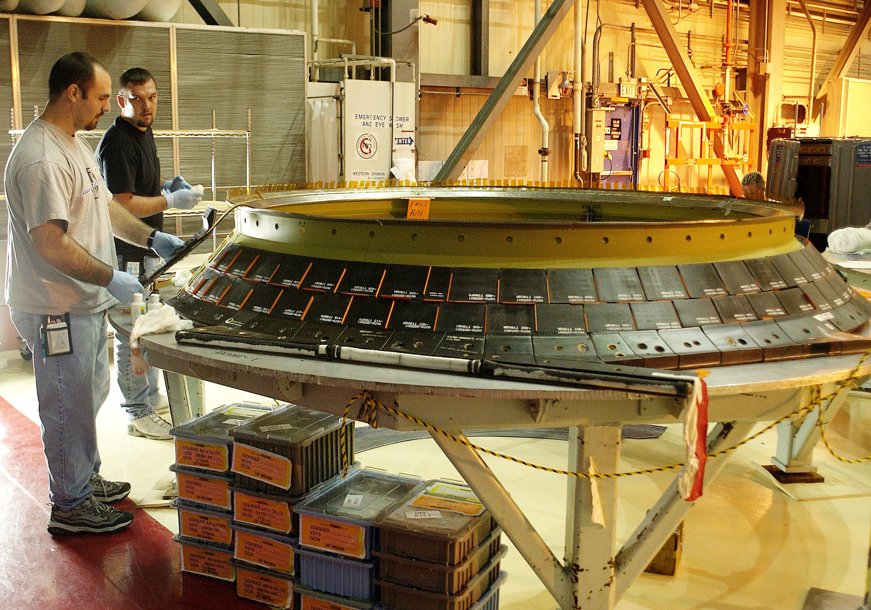 KENNEDY SPACE CENTER, FLA. - United Space Alliance employees Jeremy Schwarz (left) and Chris Keeling install new tiles on the heat shield of main engine 1 for the orbiter Discovery. A heat shield is a protective layer on a spacecraft designed to protect it from the high temperatures, usually those that result from aerobraking during reentry into the Earth’s atmosphere.