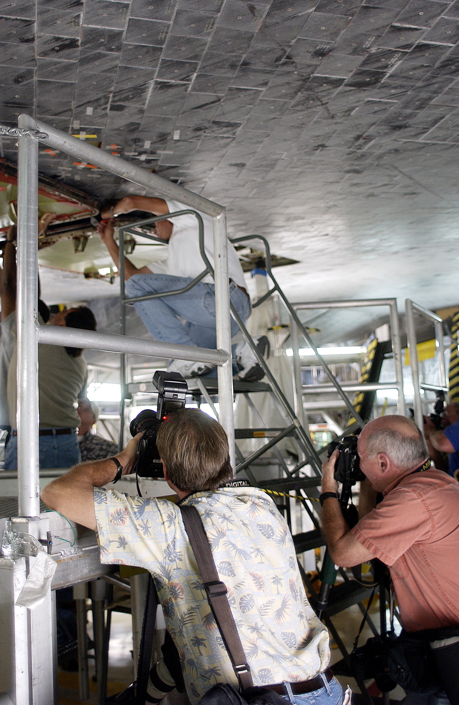 KENNEDY SPACE CENTER, FLA. - In the Orbiter Processing Facility, the media photograph work being done on the tiles on the orbiter Atlantis as it is being prepared for Return to Flight in the Orbiter Processing Facility. Both local and national reporters representing print and TV networks were able to see work in progress on Atlantis, including the reinstallation of the Reinforced Carbon-Carbon panels on the orbiter’s wing leading edge; wiring inspections; and checks of the engines in the Orbital Maneuvering System.