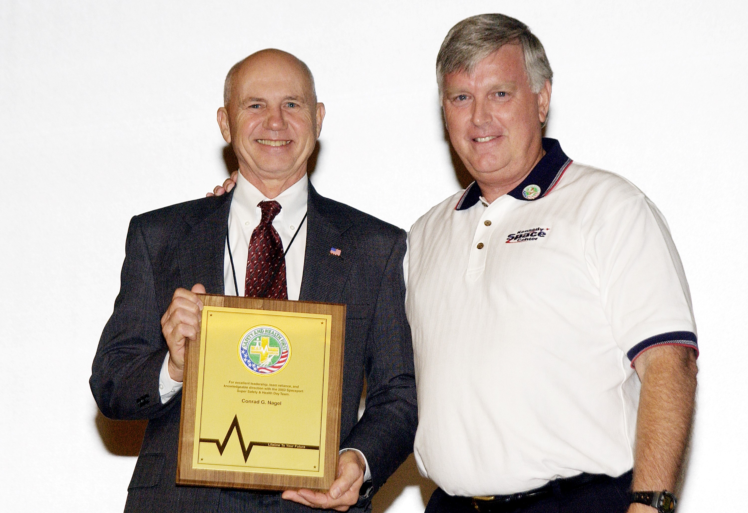 KENNEDY SPACE CENTER, FLA. - Center Director Jim Kennedy (right) presents a plaque to Conrad Nagel who organized the Spaceport Super Safety and Health Day at KSC, an annual event dedicated to reinforcing safe and healthful behaviors in the workforce. Nagel is chief of the Shuttle Project Office, Shuttle Processing.