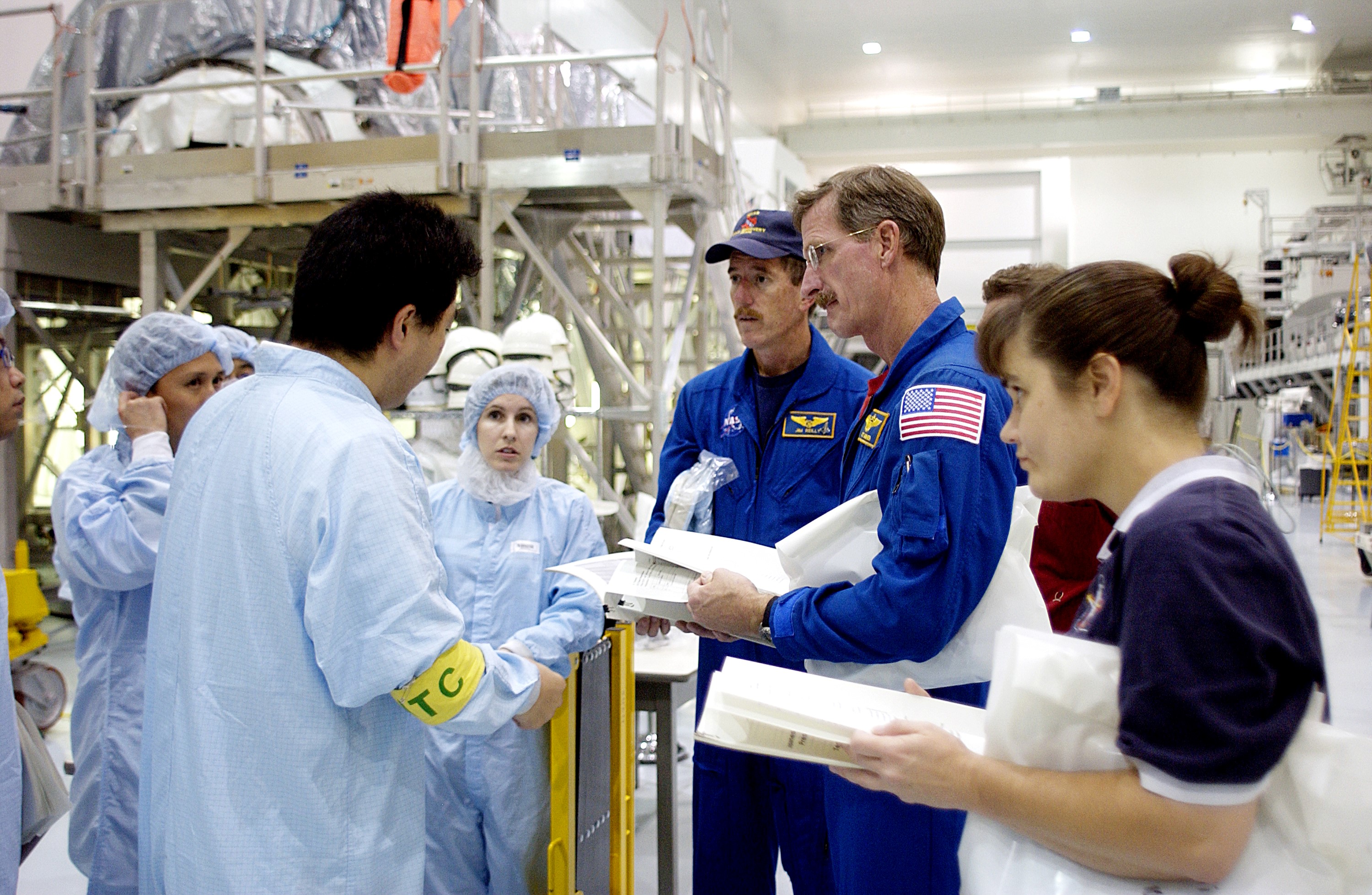 KENNEDY SPACE CENTER, FLA. - In the Space Station Processing Facility, workers (in protective clothing) brief STS-117 Mission Specialist James Reilly (center) and STS-115 Mission Specialist Joseph Tanner (right) about the Japanese Experiment Module (JEM). Equipment familiarization is a routine part of astronaut training and launch preparations.