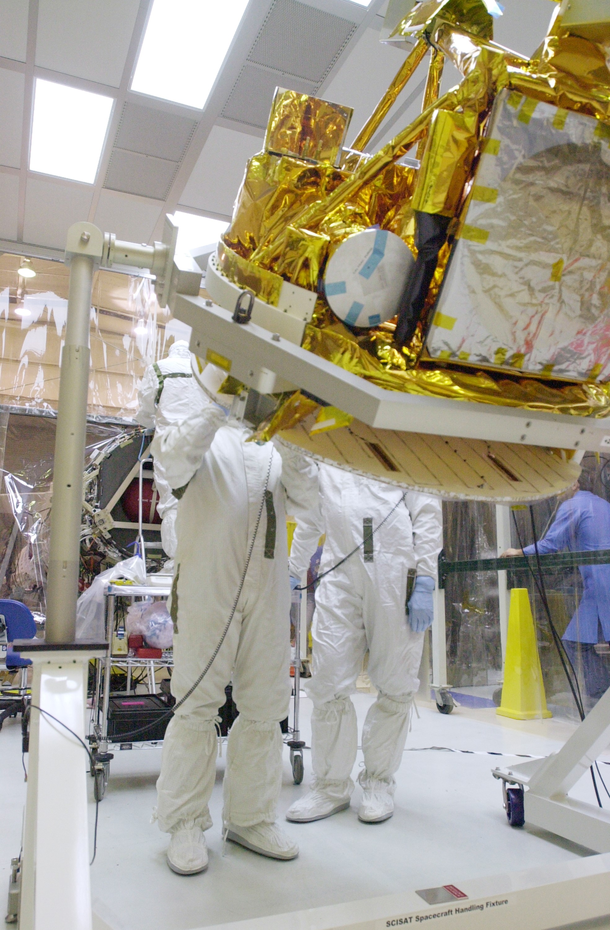 VANDENBERG AIR FORCE BASE, CALIF. - With its cover removed, the SciSat-1 spacecraft is rotated. The solar arrays will be attached and the communications systems checked out. The SciSat-1 weighs approximately 330 pounds and after launch will be placed in a 400-mile-high polar orbit to investigate processes that control the distribution of ozone in the upper atmosphere. The data from the satellite will provide Canadian and international scientists with improved measurements relating to global ozone processes and help policymakers assess existing environmental policy and develop protective measures for improving the health of our atmosphere, preventing further ozone depletion. The mission is designed to last two years.