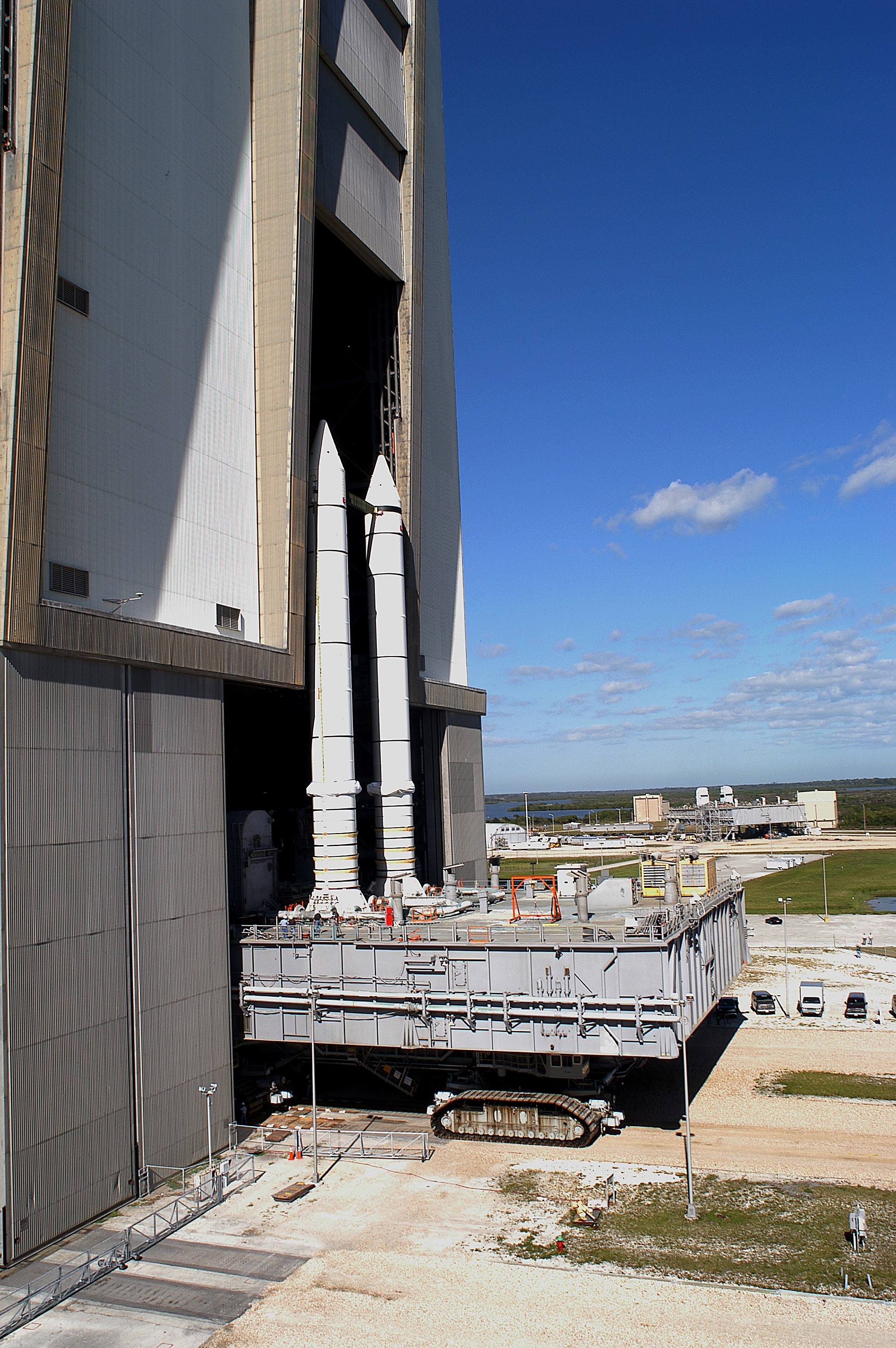 KENNEDY SPACE CENTER, FLA. - Mobile Launcher Platform (MLP) number 3 and a set of twin solid rocket boosters, atop the crawler-transporter, crawl out of the Vehicle Assembly Building (VAB) in support of the second engineering analysis vibration test on the crawler and MLP. In the background is another MLP. The crawler is moving at various speeds up to 1 mph in an effort to achieve vibration data gathering goals as it leaves the VAB, travels toward Launch Pad 39A and then returns. The boosters are braced at the top for stability. The primary purpose of these rollout tests is to gather data to develop future maintenance requirements on the transport equipment and the flight hardware. Various parts of the MLP and crawler transporter have been instrumented with vibration data collection equipment.
