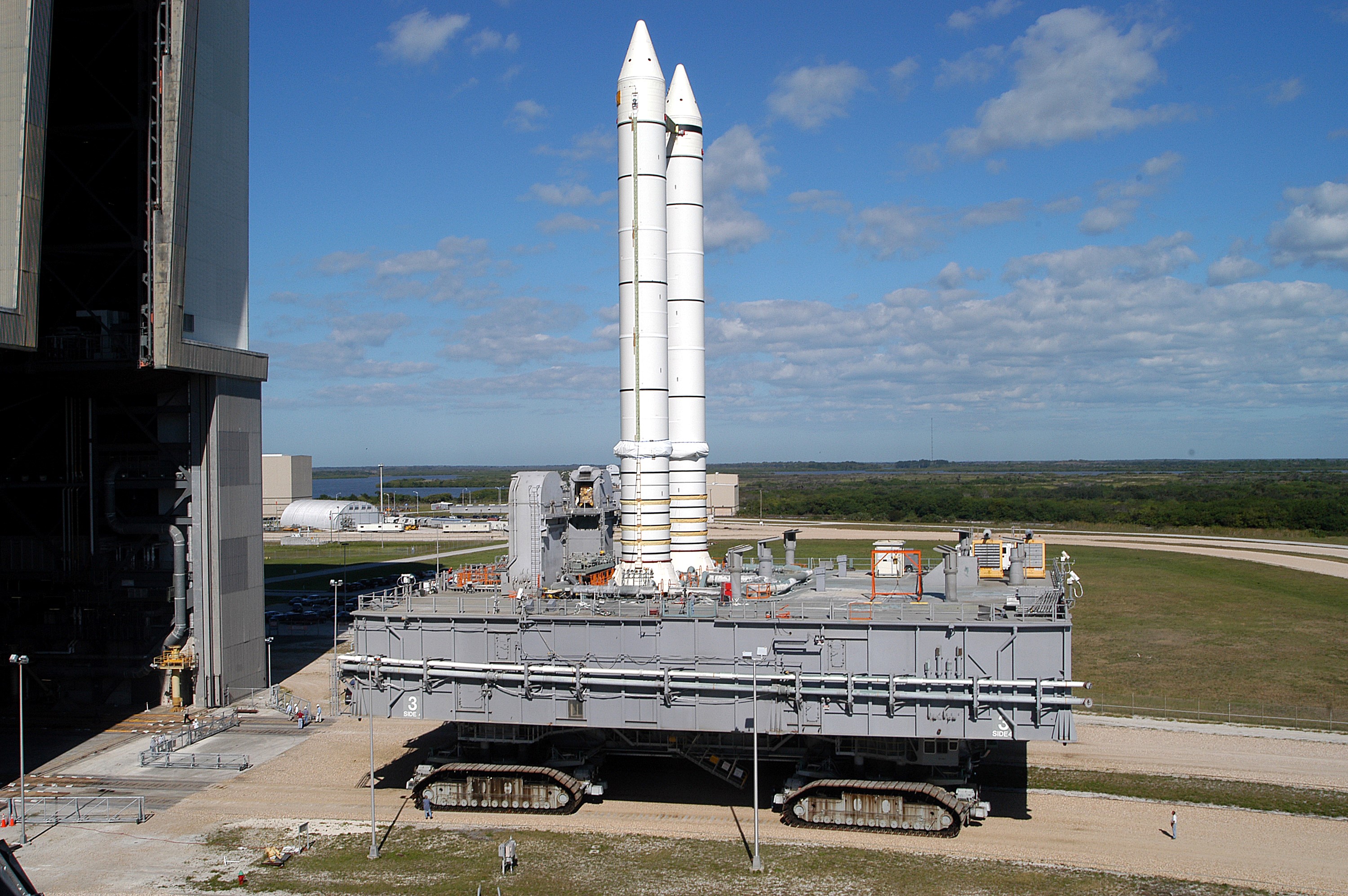 KENNEDY SPACE CENTER, FLA. - Mobile Launcher Platform (MLP) number 3 and a set of twin solid rocket boosters, atop the crawler-transporter, inch away from the Vehicle Assembly Building (VAB) in support of the second engineering analysis vibration test on the crawler and MLP. The crawler is moving at various speeds up to 1 mph in an effort to achieve vibration data gathering goals as it leaves the VAB, travels toward Launch Pad 39A and then returns. The boosters are braced at the top for stability. The primary purpose of these rollout tests is to gather data to develop future maintenance requirements on the transport equipment and the flight hardware. Various parts of the MLP and crawler transporter have been instrumented with vibration data collection equipment.