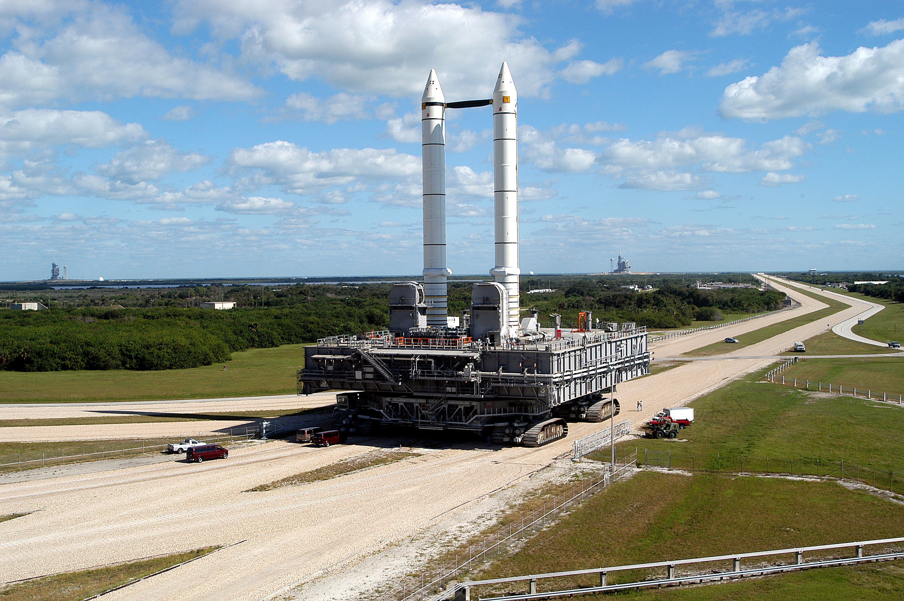 KENNEDY SPACE CENTER, FLA. - Mobile Launcher Platform (MLP) number 3 and a set of twin solid rocket boosters, atop the crawler-transporter, inch along the crawlerway in support of the second engineering analysis vibration test on the crawler and MLP. The crawler is moving at various speeds up to 1 mph in an effort to achieve vibration data gathering goals as it leaves the VAB, travels toward Launch Pad 39A (on the horizon at right; Pad 39B is at far left), and then returns. The boosters are braced at the top for stability. The primary purpose of these rollout tests is to gather data to develop future maintenance requirements on the transport equipment and the flight hardware. Various parts of the MLP and crawler transporter have been instrumented with vibration data collection equipment.