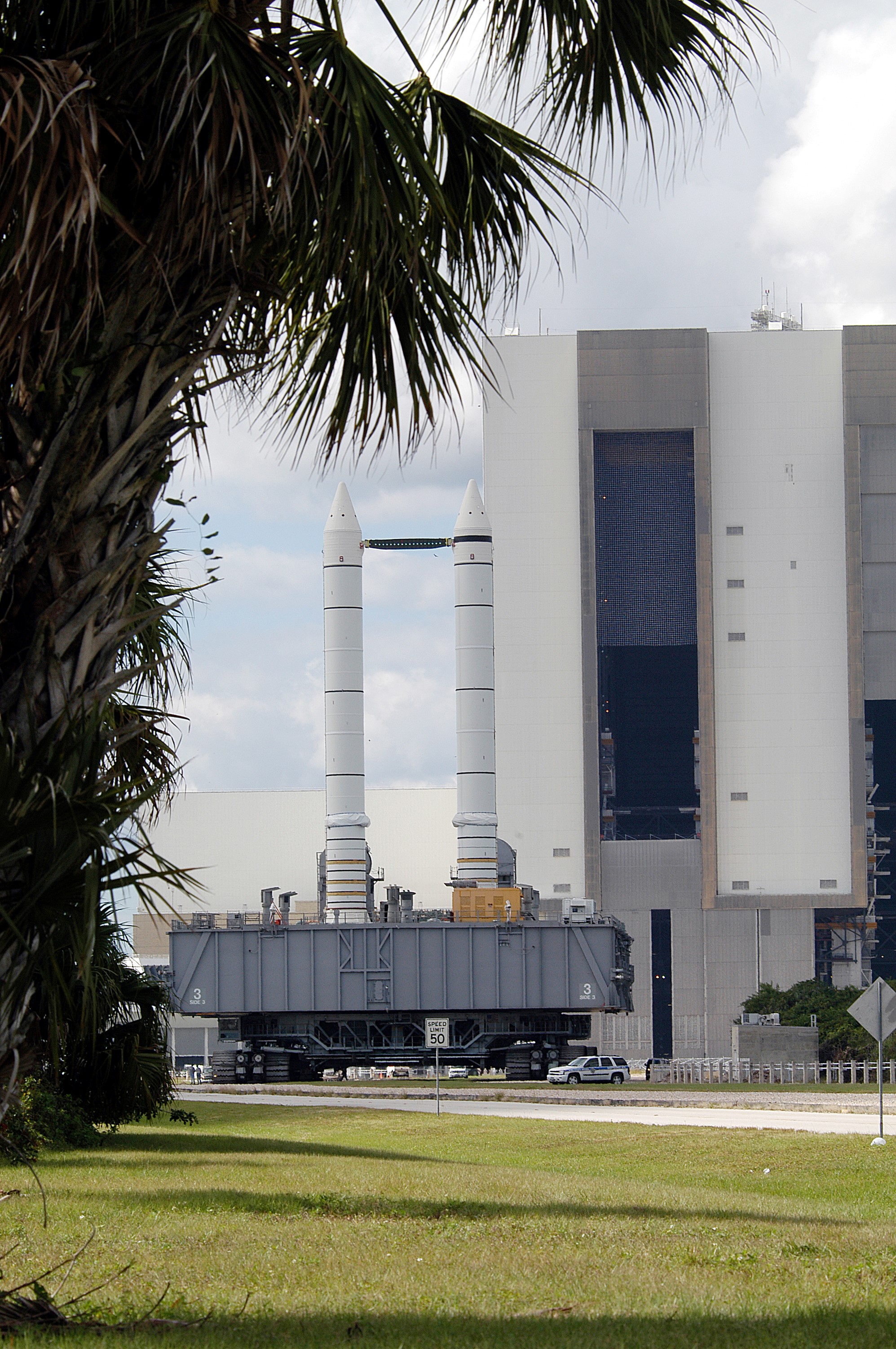 KENNEDY SPACE CENTER, FLA. - Mobile Launcher Platform (MLP) number 3 and a set of twin solid rocket boosters, atop the crawler-transporter, crawls away from the Vehicle Assembly Building in support of the second engineering analysis vibration test on the crawler and MLP. The crawler is moving at various speeds up to 1 mph in an effort to achieve vibration data gathering goals as it leaves the VAB, travels toward Launch Pad 39A and then returns. The boosters are braced at the top for stability. The primary purpose of these rollout tests is to gather data to develop future maintenance requirements on the transport equipment and the flight hardware. Various parts of the MLP and crawler transporter have been instrumented with vibration data collection equipment.