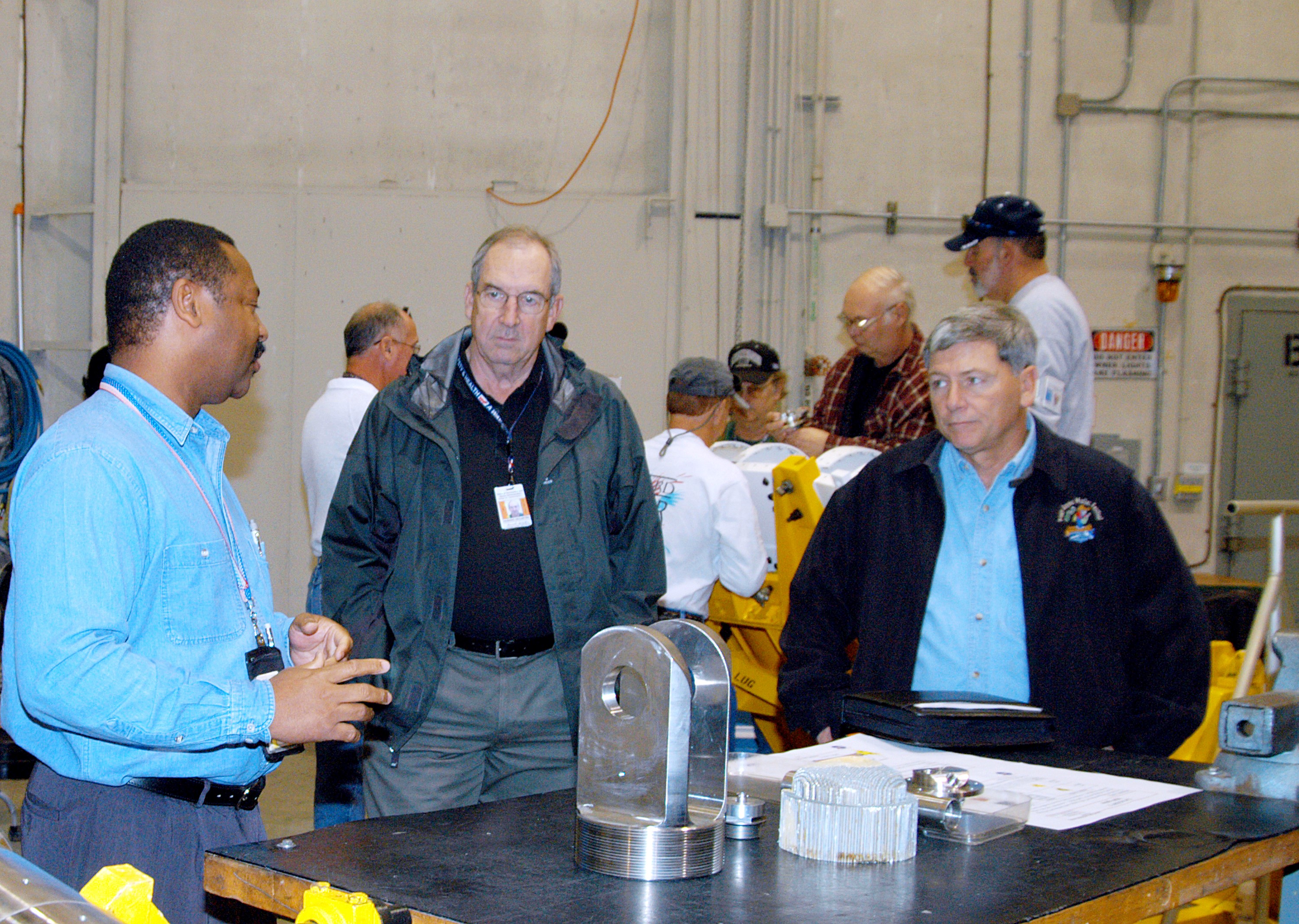 KENNEDY SPACE CENTER, FLA. -- From left, a United Space Alliance (USA) technician discusses aspects of Shuttle processing performed in the Solid Rocket Booster (SRB) Assembly and Refurbishment Facility (ARF) with USA Vice President and Space Shuttle Program Manager Howard DeCastro and NASA Deputy Associate Administrator for Space Station and Shuttle Programs Michael Kostelnik. NASA and USA Space Shuttle program management are participating in a leadership workday. The day is intended to provide management with an in-depth, hands-on look at Shuttle processing activities at KSC.