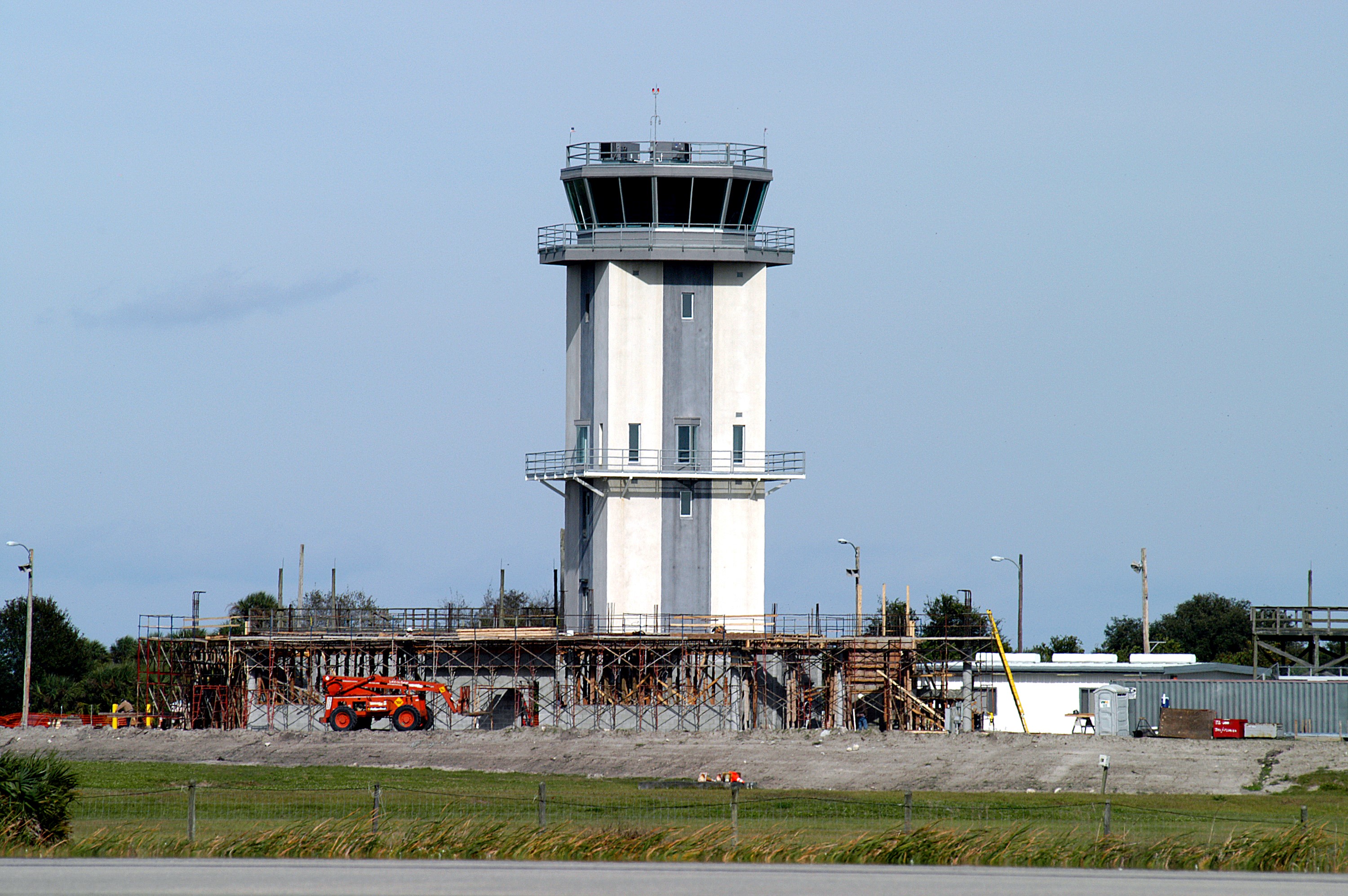 KENNEDY SPACE CENTER, FLA. -- A new control tower is nearing completion at the KSC Shuttle Landing Facility. It will replace the old tower in use since 1987. The old tower stands only 20 feet above the runway surface, too low to see the launch pads to the east. During nighttime landing operations, those inside the tower have been hindered by the eight-billion candlepower xenon lights that illuminate the runway. The new control tower is built atop an existing mound, rising nearly 100 feet over the midpoint of the runway. The height gives controllers a spectacular 360-degree view of NASA-KSC and northern Brevard County. The new facility will also replace the SLF Operations Building. The operations building is home to the Military Radar Unit that monitors NASA-KSC airspace 24 hours a day, as well as runway light controls, navigational aids, weather and wind speed instrumentation, and gate controls. In the new tower, the computer displays will be fully modernized to Federal Aviation Administration standards with touch-screen technology. Construction on the new facility began in February 2003 and is nearly ready for occupancy. Only some final inspections and approvals remain. A support building and Public Affairs viewing deck, to be used for observing future landing operations, will be added and are already in work.
