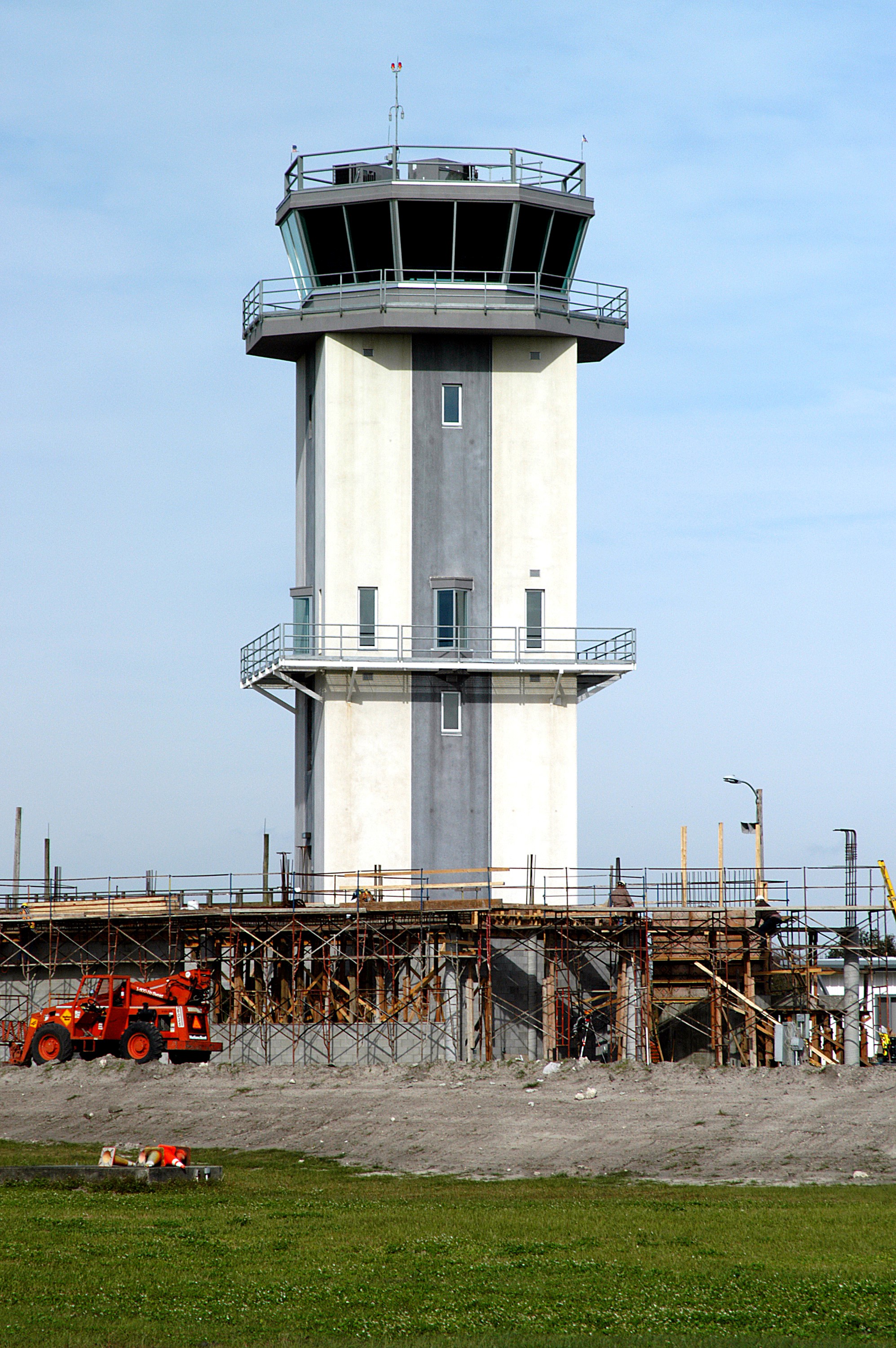 KENNEDY SPACE CENTER, FLA. -- A new control tower is nearing completion at the KSC Shuttle Landing Facility. It will replace the old tower in use since 1987. The old tower stands only 20 feet above the runway surface, too low to see the launch pads to the east. During nighttime landing operations, those inside the tower have been hindered by the eight-billion candlepower xenon lights that illuminate the runway. The new control tower is built atop an existing mound, rising nearly 100 feet over the midpoint of the runway. The height gives controllers a spectacular 360-degree view of NASA-KSC and northern Brevard County. The new facility will also replace the SLF Operations Building. The operations building is home to the Military Radar Unit that monitors NASA-KSC airspace 24 hours a day, as well as runway light controls, navigational aids, weather and wind speed instrumentation, and gate controls. In the new tower, the computer displays will be fully modernized to Federal Aviation Administration standards with touch-screen technology. Construction on the new facility began in February 2003 and is nearly ready for occupancy. Only some final inspections and approvals remain. A support building and Public Affairs viewing deck, to be used for observing future landing operations, will be added and are already in work.
