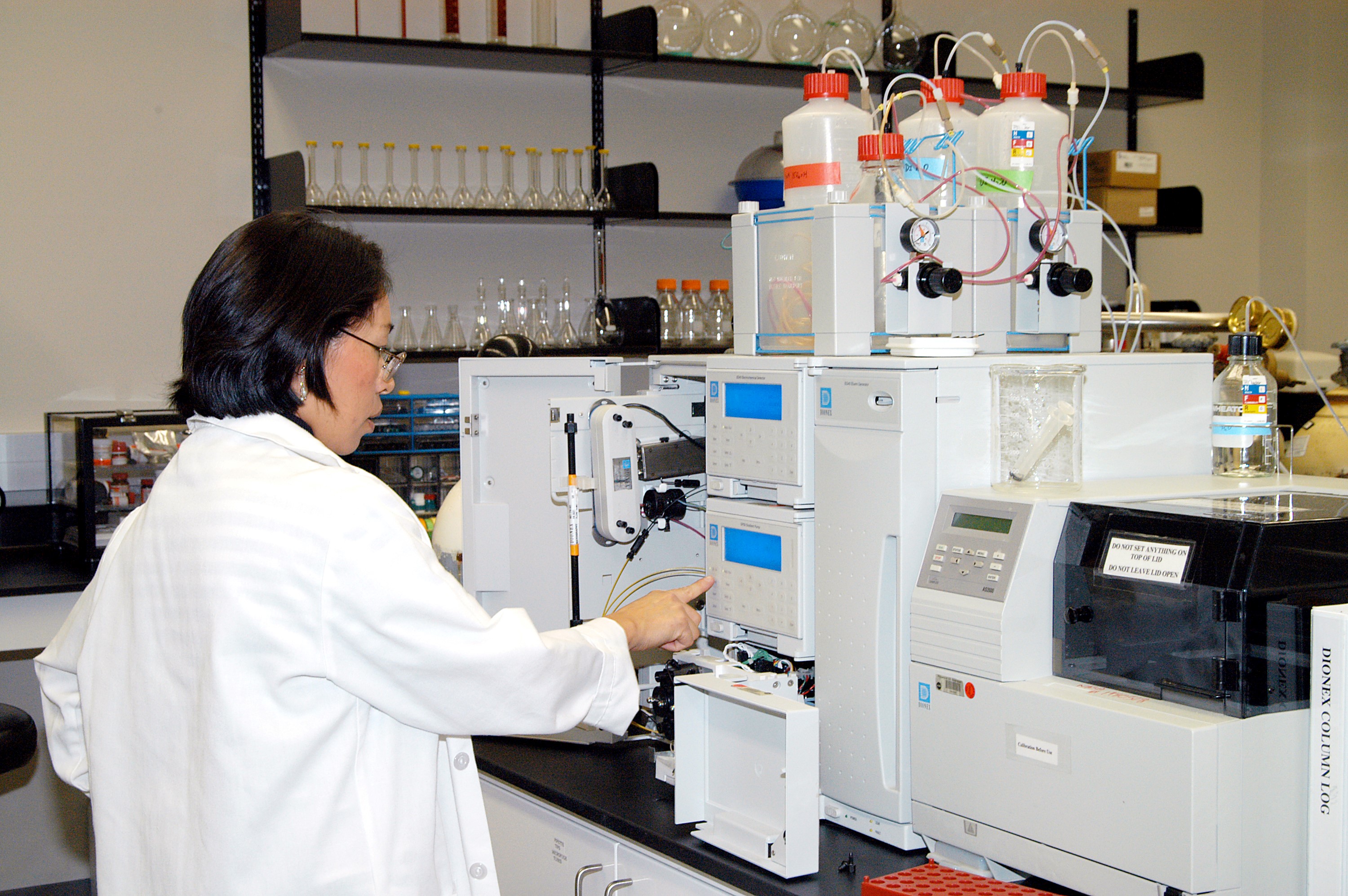 KENNEDY SPACE CENTER, FLA. -- Lanfang Levine, with Dynamac Corp., helps install a Dionex DX-500 IC/HPLC system in the Space Life Sciences Lab. The equipment will enable analysis of volatile compounds, such as from plants. The 100,000 square-foot facility houses labs for NASA’s ongoing research efforts, microbiology/microbial ecology studies and analytical chemistry labs. Also calling the new lab home are facilities for space flight-experiment and flight-hardware development, new plant growth chambers, and an Orbiter Environment Simulator that will be used to conduct ground control experiments in simulated flight conditions for space flight experiments. The SLS Lab, formerly known as the Space Experiment Research and Processing Laboratory or SERPL, provides space for NASA’s Life Sciences Services contractor Dynamac Corporation, Bionetics Corporation, and researchers from the University of Florida. NASA’s Office of Biological and Physical Research will use the facility for processing life sciences experiments that will be conducted on the International Space Station. The SLS Lab is the magnet facility for the International Space Research Park at KSC being developed in partnership with Florida Space Authority.