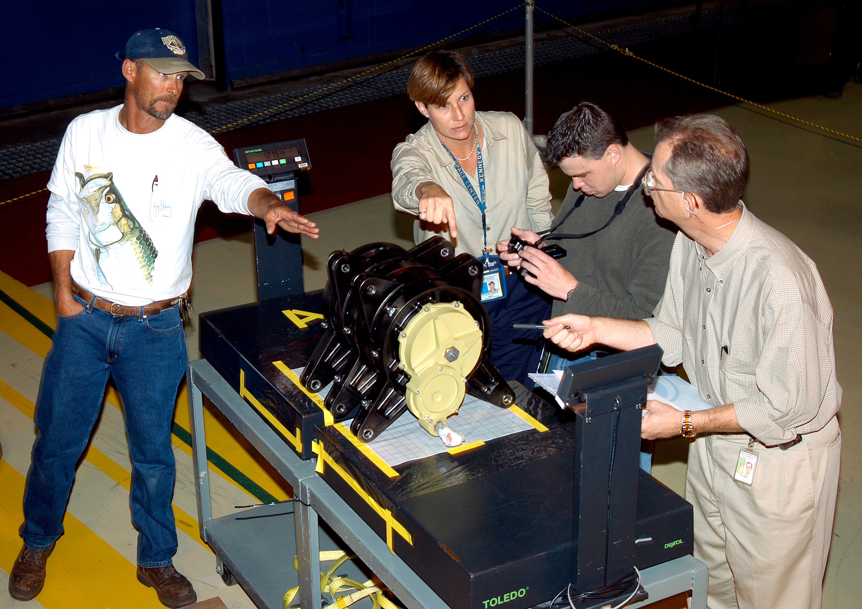 KENNEDY SPACE CENTER, FLA. - Workers in the Orbiter Processing Facility measure the alignment of bearings on a rudder speed brake actuator. Actuators move an orbiter’s rudder, speed brake, elevons and main engines during flight.