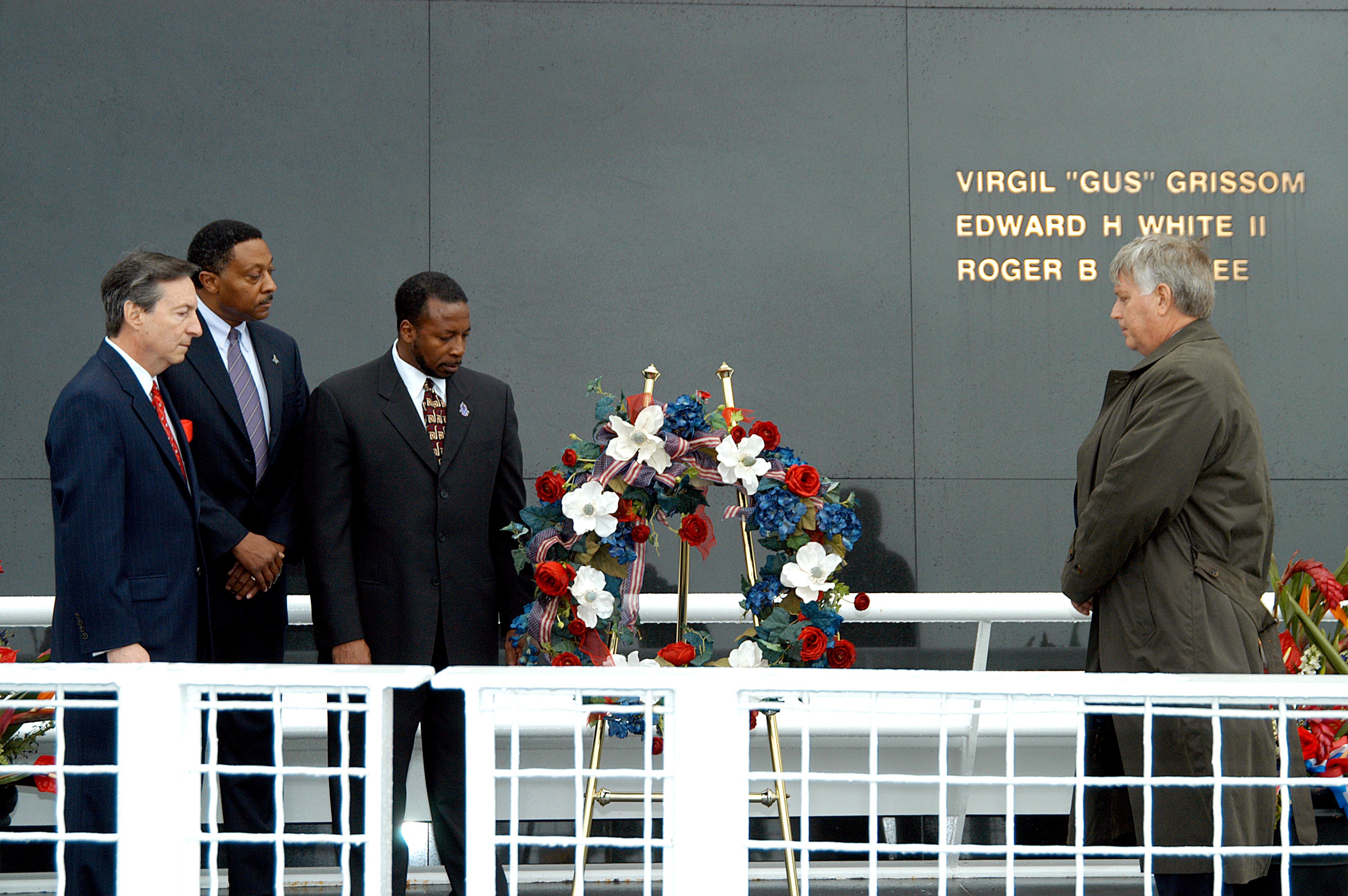 KENNEDY SPACE CENTER, FLA. - During a memorial service remembering and honoring the crew of Columbia, President of the Astronaut Memorial Foundation Dr. Stephen Feldman, Executive Director of Florida Space Authority Winston Scott, KSC Deputy Director Woodrow Whitlow Jr. and Center Director Jim Kennedy pause after placing a wreath in front of the Space Memorial Mirror. Feb. 1 is the one-year anniversary of the loss of the crew and orbiter Columbia in a tragic accident as the ship returned to Earth following mission STS-107. Scott is a former astronaut who flew on Columbia in 1997. The public was also invited to the memorial service.