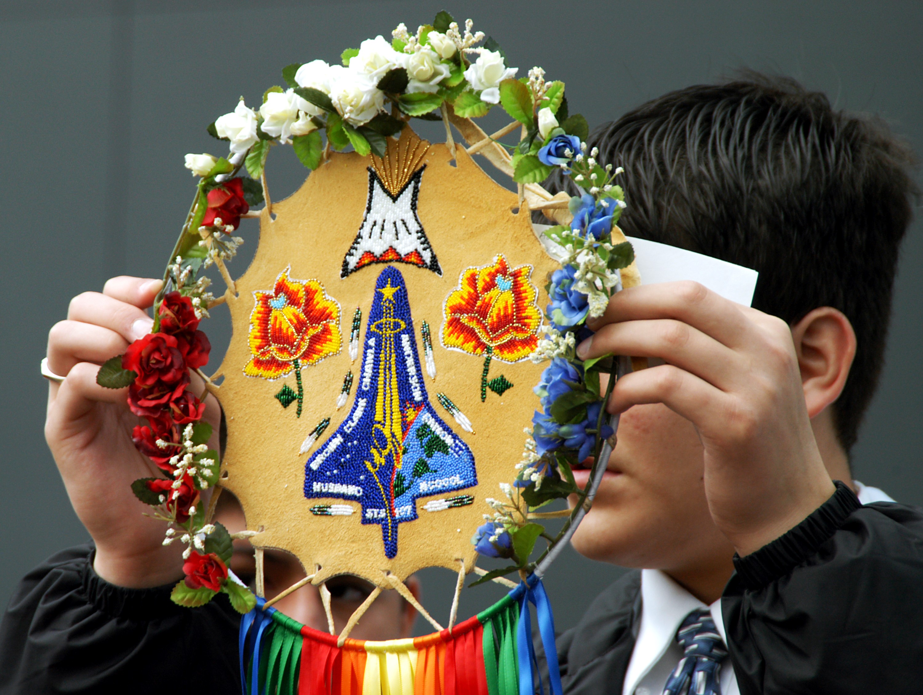 KENNEDY SPACE CENTER, FLA. - A member of the Shoshone-Bannock Native American community from Fort Hall, Idaho, displays a handmade item with the STS-107 logo. Dancers from Shoshone-Bannock Junior-Senior High School performed a healing ceremony during the memorial held at the Space Memorial Mirror, in the KSC Visitor Complex. Feb. 1 is the one-year anniversary of the loss of the crew and orbiter Columbia in a tragic accident as the ship returned to Earth following mission STS-107. Students and staff of the Shoshone-Bannock Nation had an experiment on board Columbia. The public was invited to the memorial service, held in the KSC Visitor Complex, which included comments by Center Director Jim Kennedy and Executive Director of Florida Space Authority Winston Scott. Scott is a former astronaut who flew on Columbia in 1997.