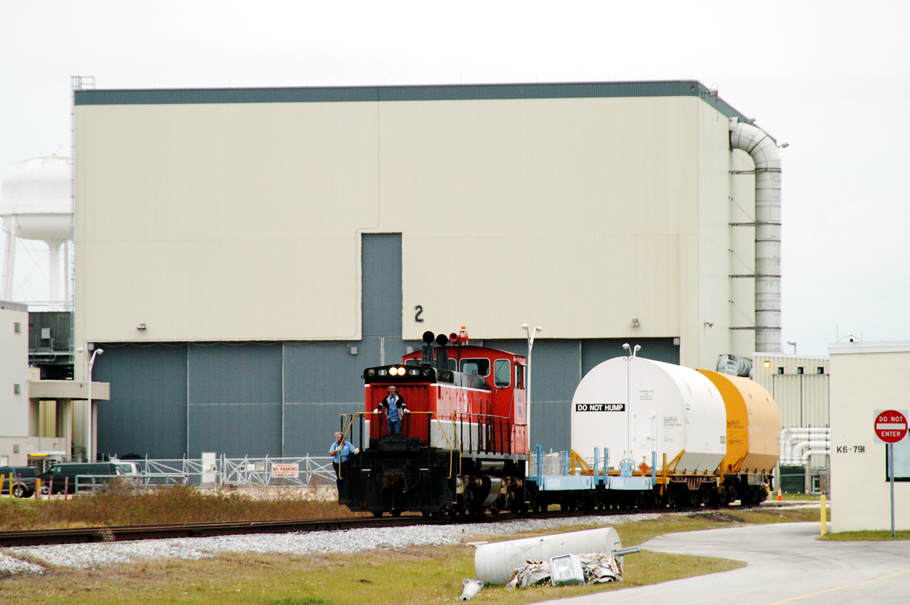 KENNEDY SPACE CENTER, FLA. - The red NASA engine backs up with its cargo of containers in order to change tracks. The containers enclose segments of a solid rocket booster being returned to Utah for testing. The segments were part of the STS-114 stack. It is the first time actual flight segments that had been stacked for flight in the VAB are being returned for testing. They will undergo firing, which will enable inspectors to check the viability of the solid and verify the life expectancy for stacked segments.