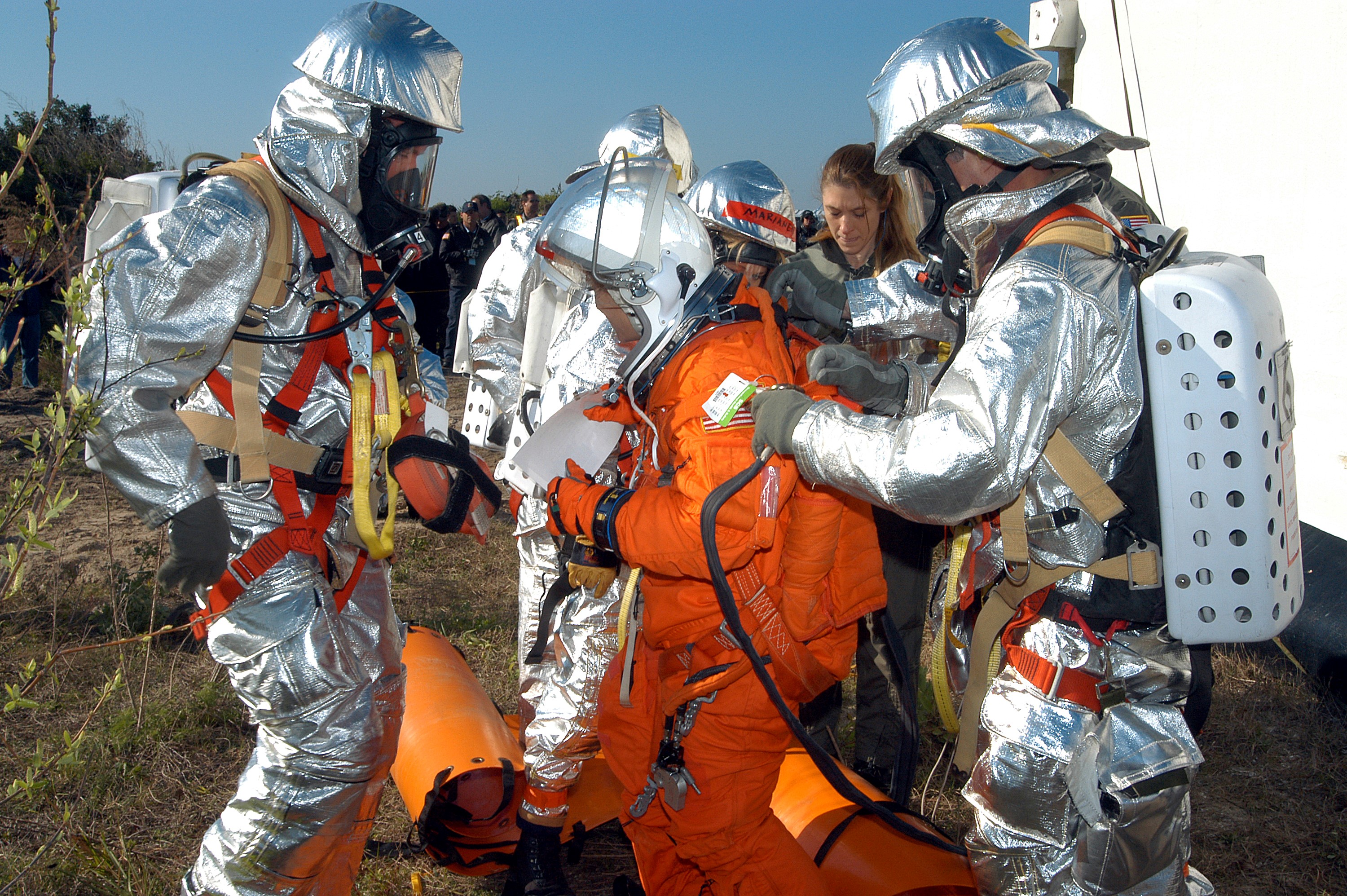 KENNEDY SPACE CENTER, FLA. - Emergency crew members help a volunteer “astronaut” onto the ground after being lowered from the top of the orbiter crew compartment mock-up that is the scene of a “Mode VII” emergency landing simulation at Kennedy Space Center. The purpose of the Mode VII is to exercise emergency preparedness personnel, equipment and facilities in rescuing astronauts from a downed orbiter and providing immediate medical attention. This simulation presents an orbiter that has crashed short of the Shuttle Landing Facility in a wooded area 2-1/2 miles south of Runway 33. Emergency crews are responding to the volunteer astronauts who are simulating various injuries. Rescuers must remove the crew, provide triage and transport to hospitals those who need further treatment. Local hospitals are participating in the exercise.
