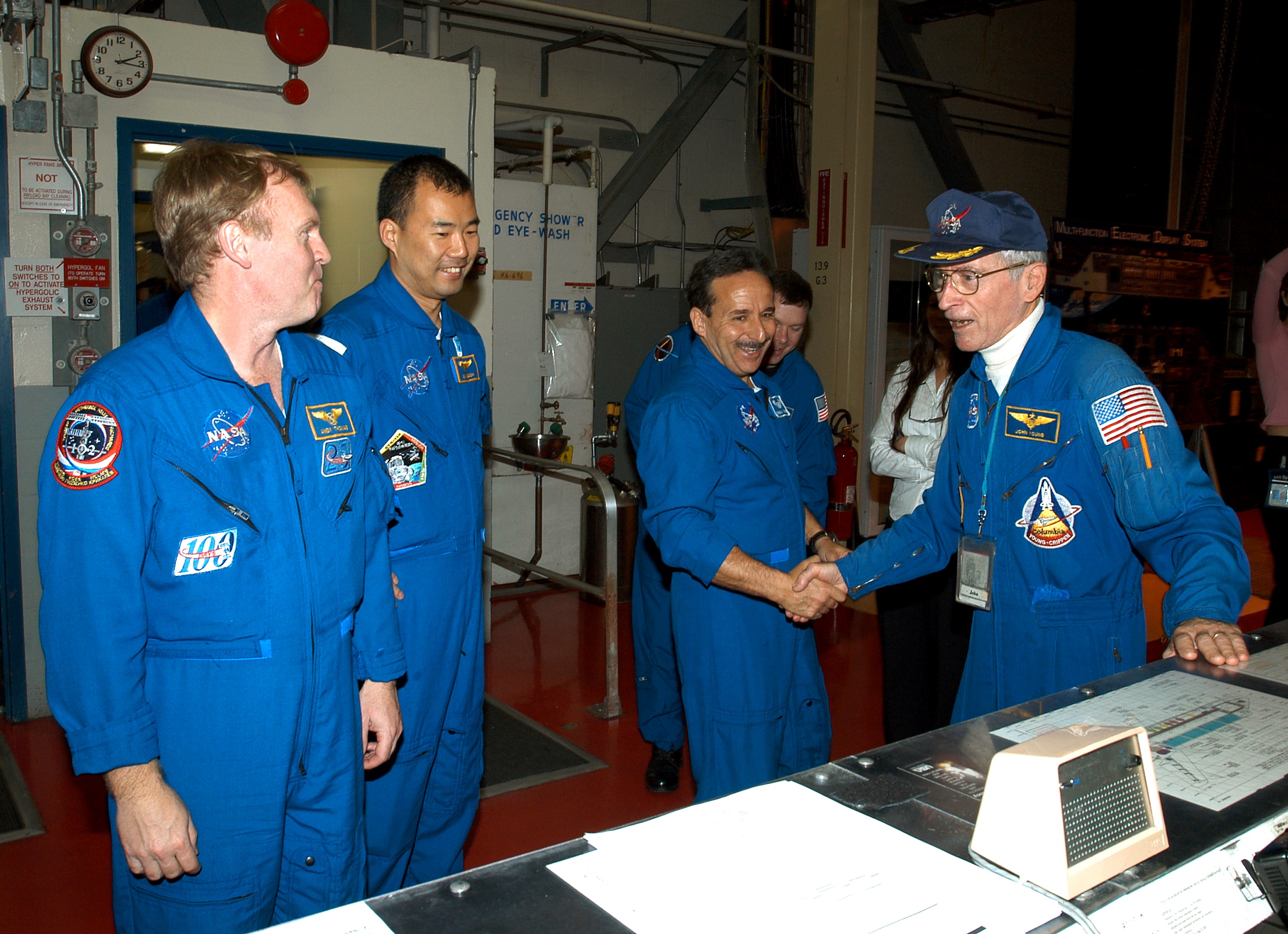 KENNEDY SPACE CENTER, FLA. - - In the Orbiter Processing Facility, STS-114 Mission Specialists Andrew Thomas, Soichi Noguchi and Charles Camarda greet astronaut John Young (far right), who flew on the first flight of Space Shuttle Columbia with Robert Crippen. Behind Camarda is Pilot James Kelly. Young is associate director, Technical, at Johnson Space Center. Noguchi represents the Japanese Aerospace and Exploration Agency. The STS-114 crew is spending time becoming familiar with Shuttle and mission equipment. The mission is Logistics Flight 1, which is scheduled to deliver supplies and equipment plus the external stowage platform to the International Space Station.