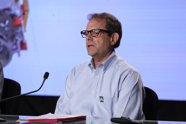 A panelist sits behind a long, illuminated desk in front a video wall featuring NASA's Nancy Grace Roman Space Telescope during a NASA news conference. 