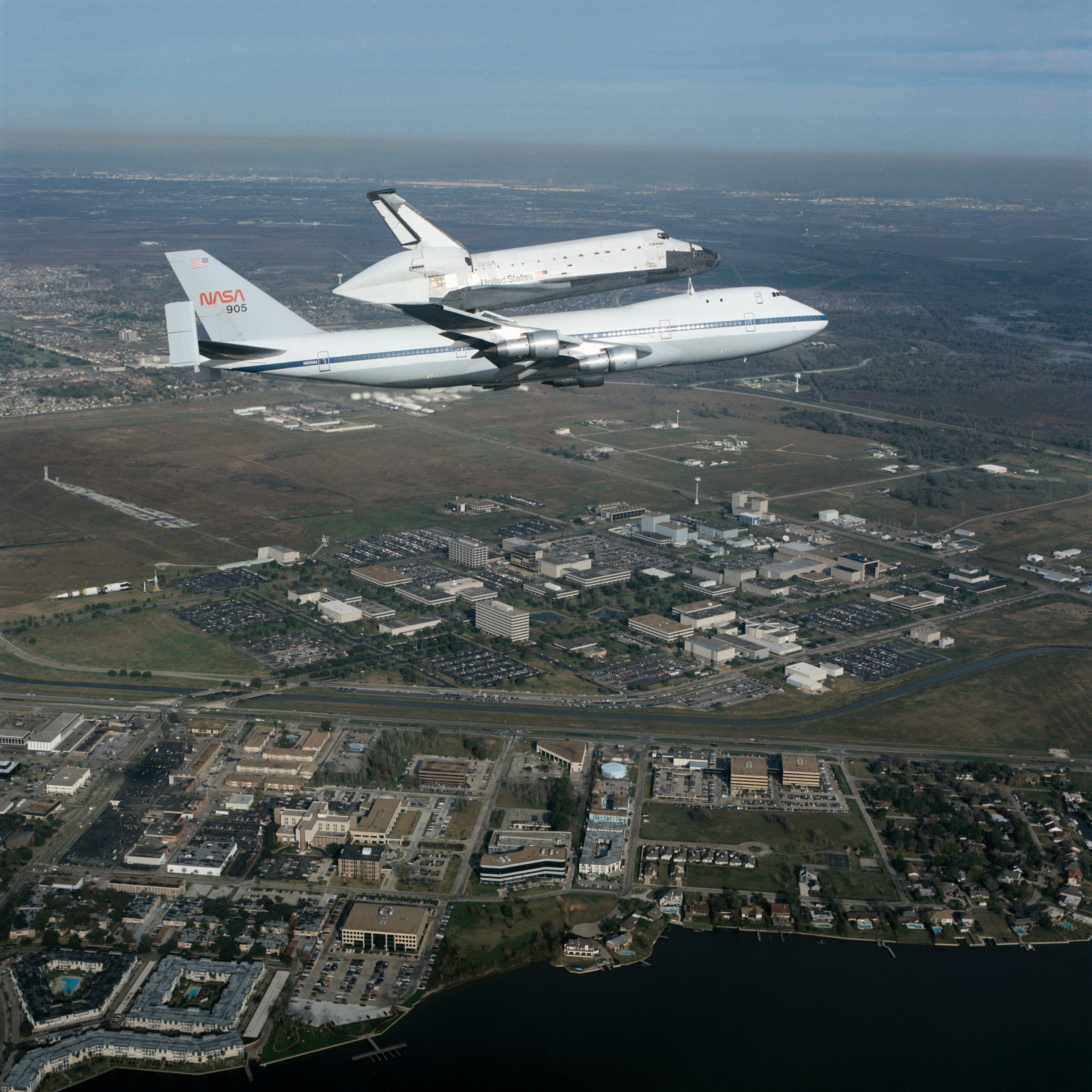 Air-to-air view of Columbia, OV-102, atop SCA NASA 905 flying over JSC site