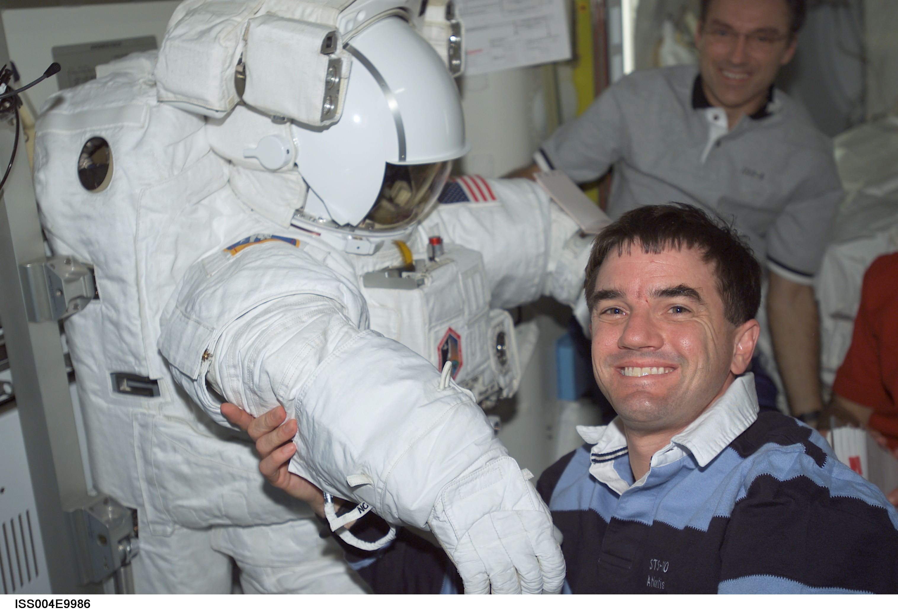 STS-110 MS Walheim poses with an EMU in the Quest A/L during Expedition Four