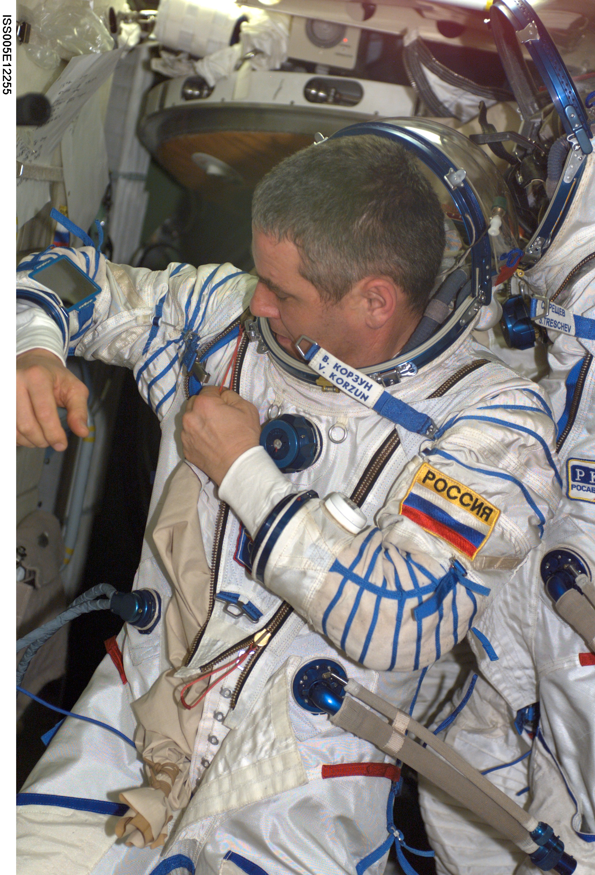 Korzun makes an adjustment to his Russian Sokol suit during Expedition Five on the ISS