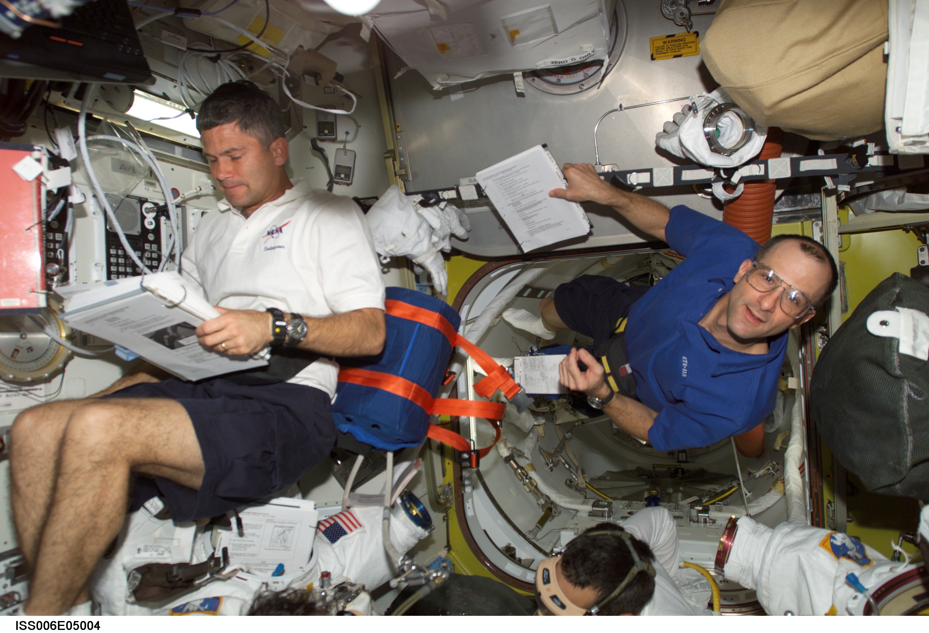 STS-113 Pilot Lockhart and Expedition Six Flight Engineer Pettit are looking over a checklist in Airlock