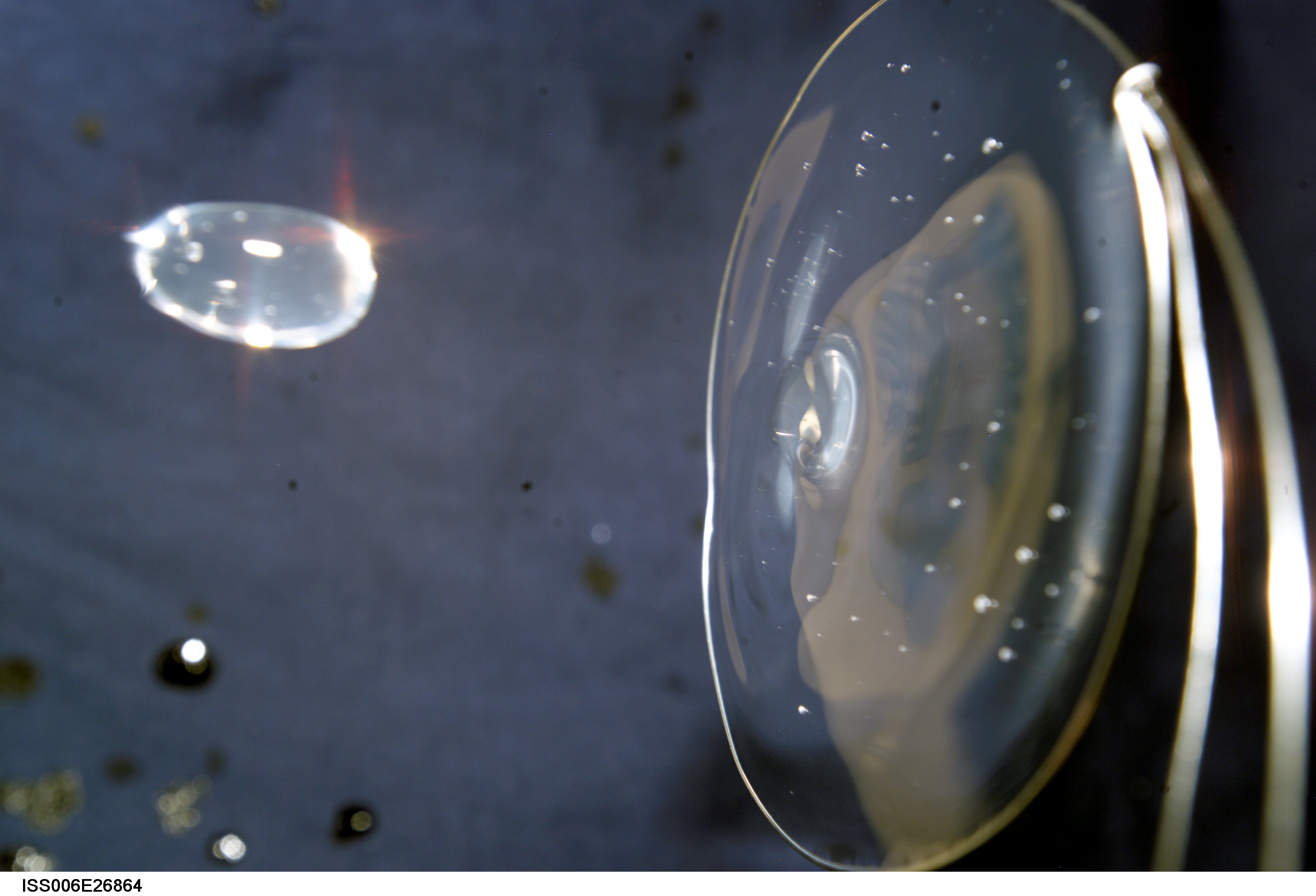 View of a surface tension demonstration using water that is being held in place by a 50mm metal loop