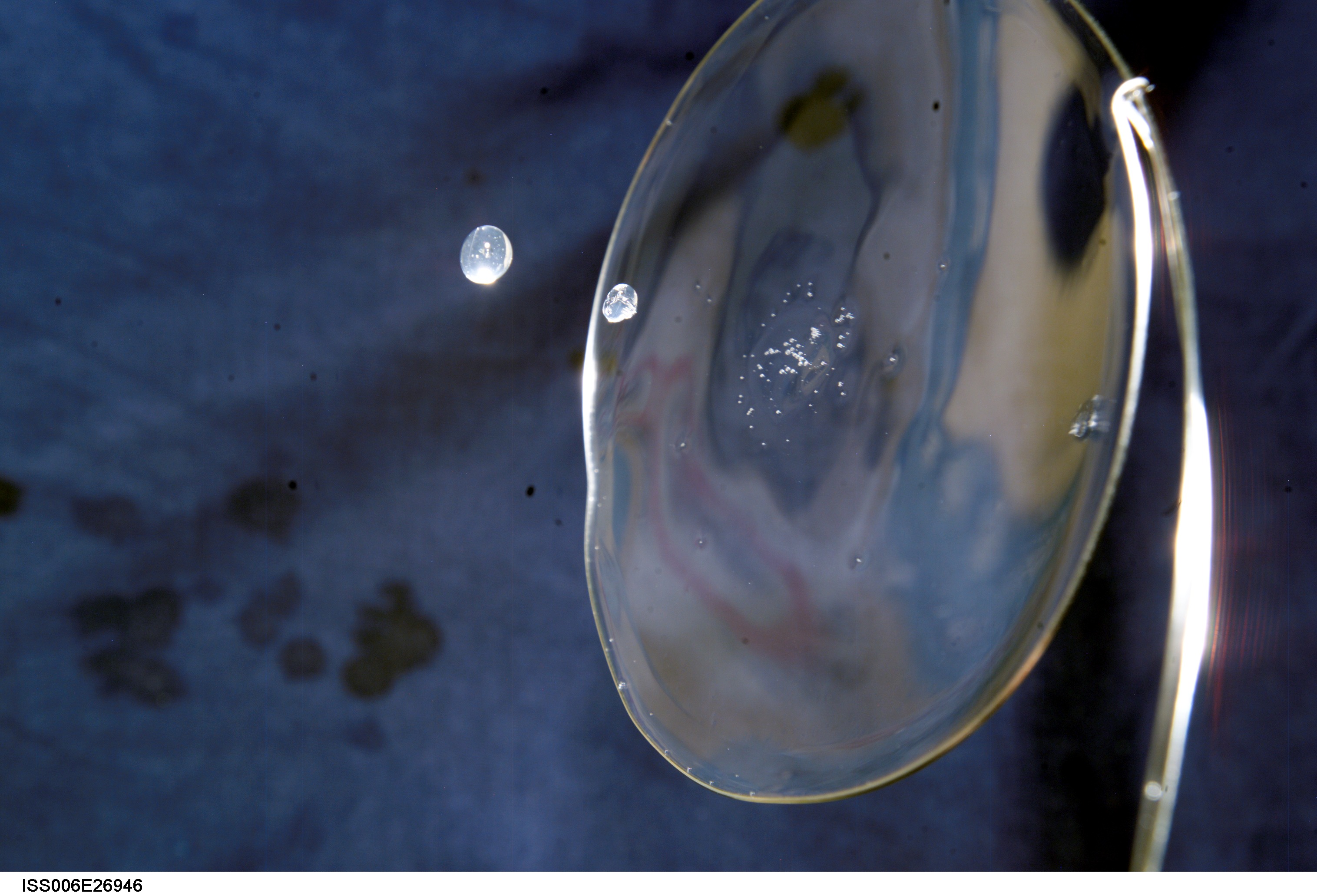 View of a surface tension demonstration using water that is being held in place by a 50mm metal loop