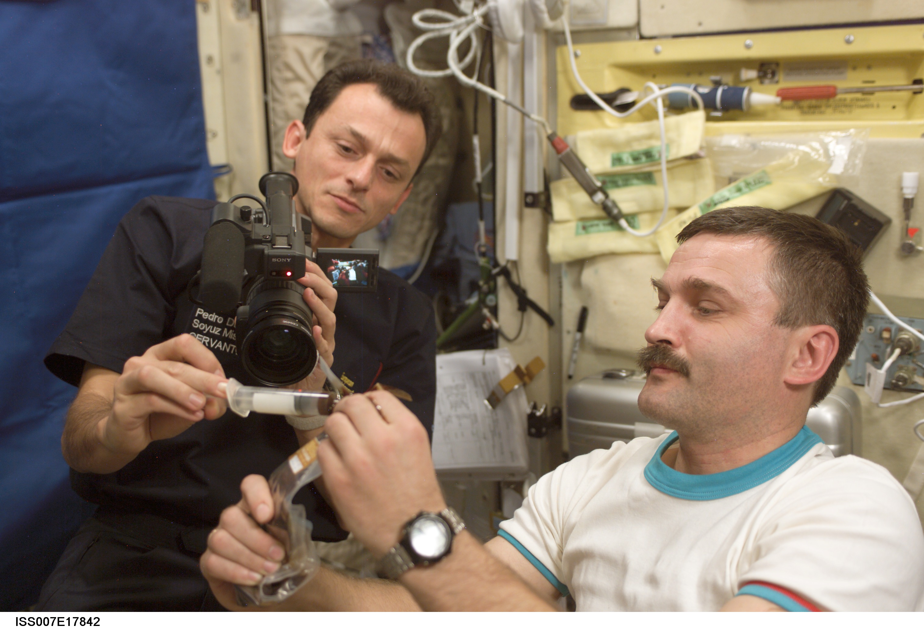 Duque and Kaleri in Zvezda Service module with video camera